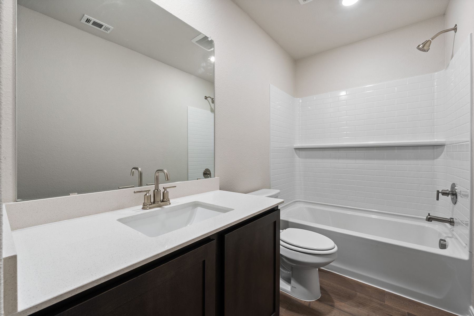The secondary bathroom of the Rayburn has a large vanity space and a shower-tub combo.