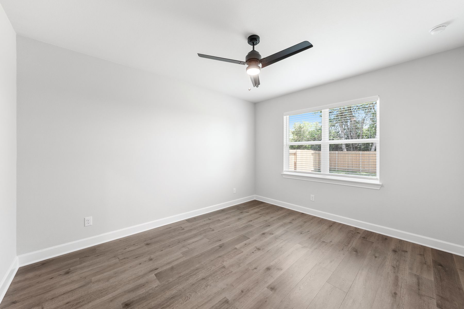 The master bedroom of the Blanco is spacious and has a large window letting great, natural light and backyard views.