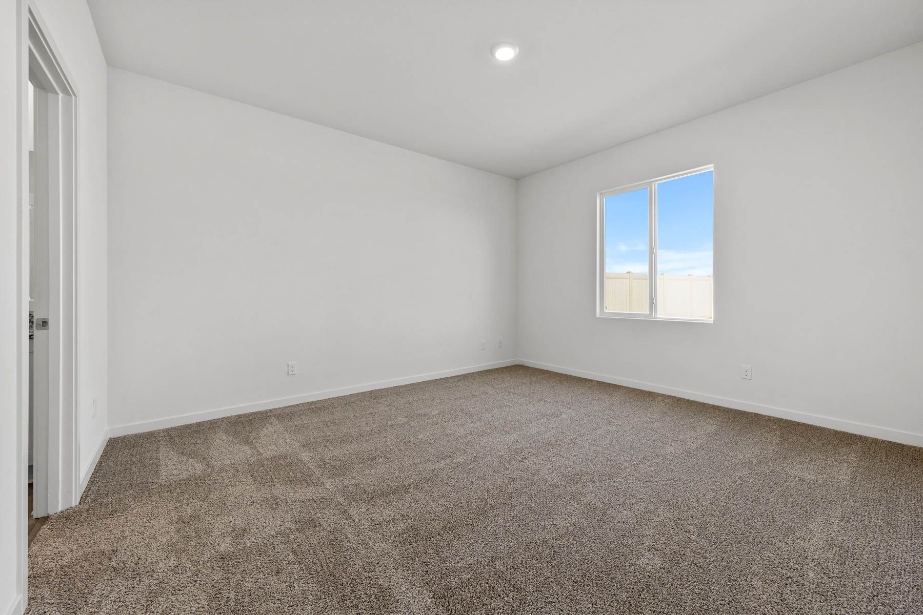 The master bedroom is spacious and has carpet.