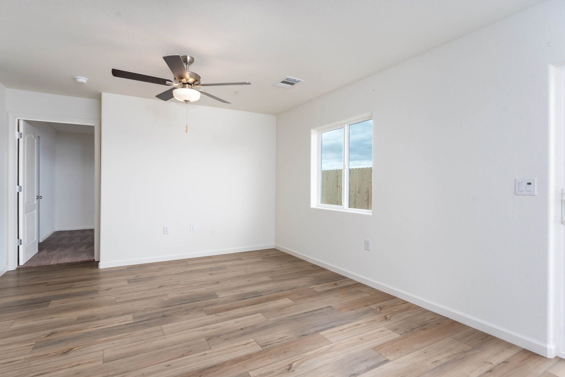 The family room is spacious with a ceiling fan.