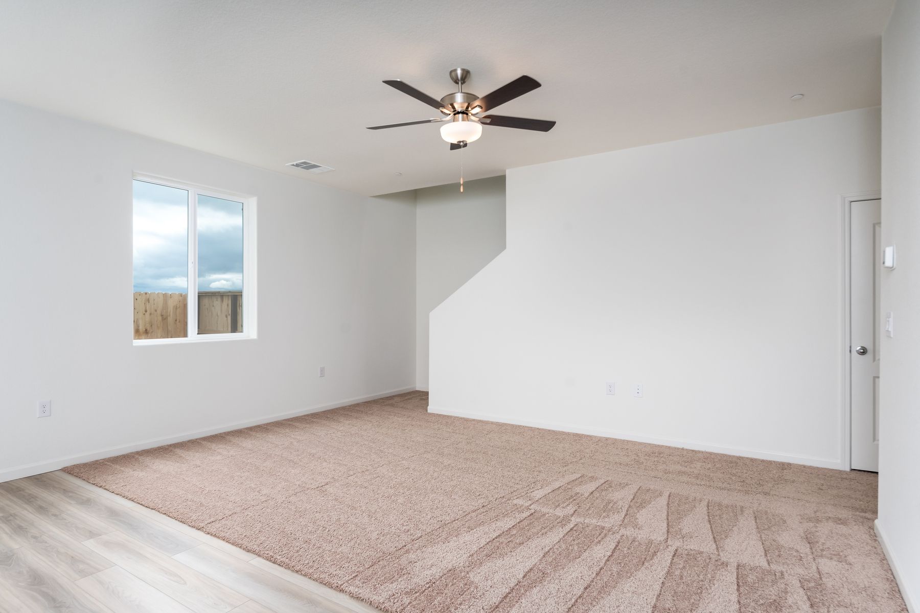 The family room is spacious with a ceiling fan.