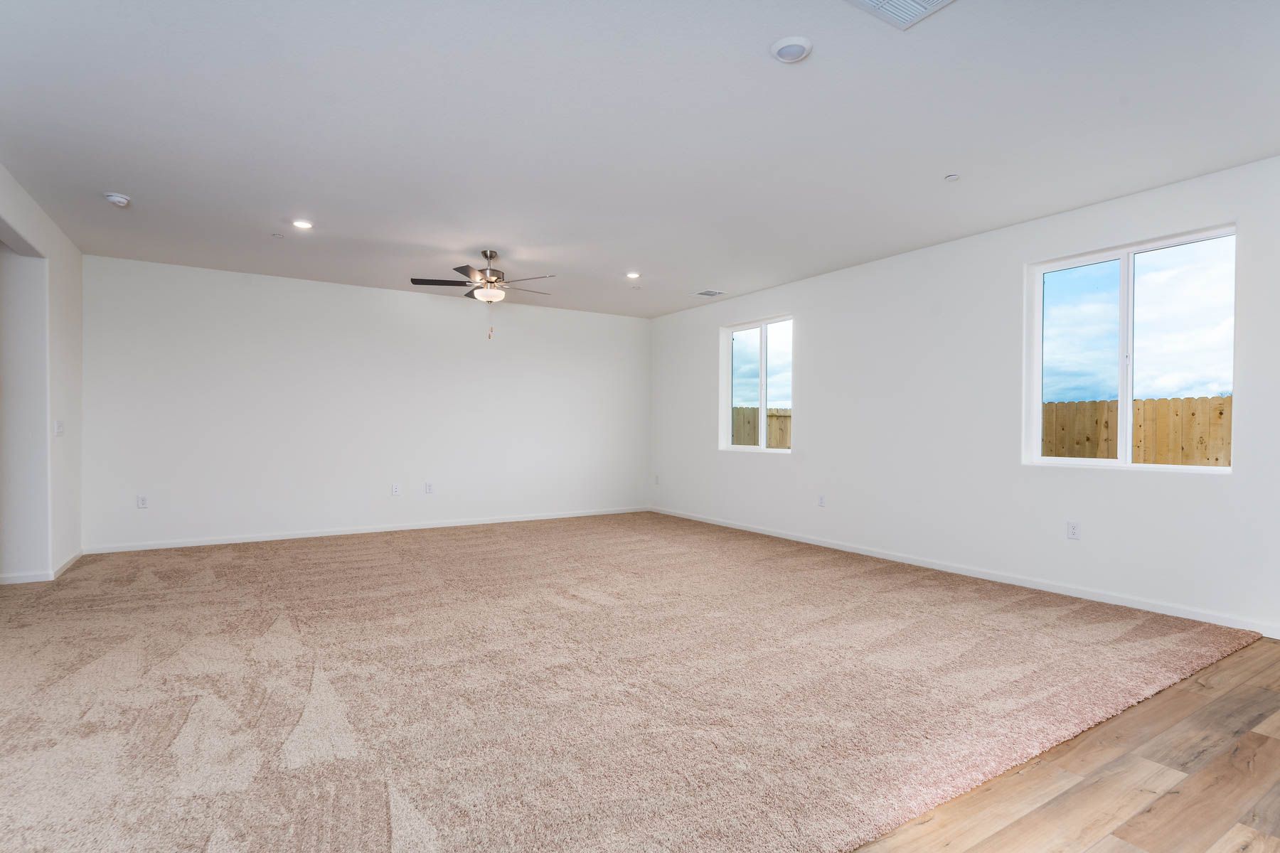The family room is spacious with a ceiling fan.