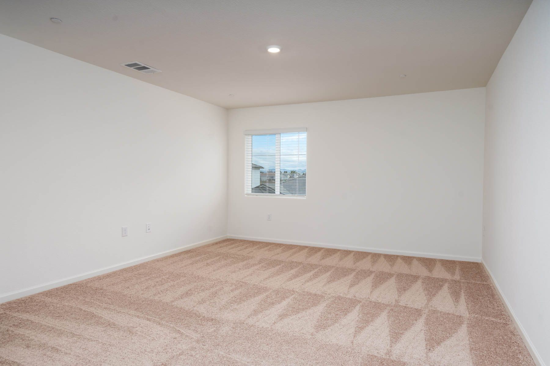 The master bedroom is spacious and has carpet.
