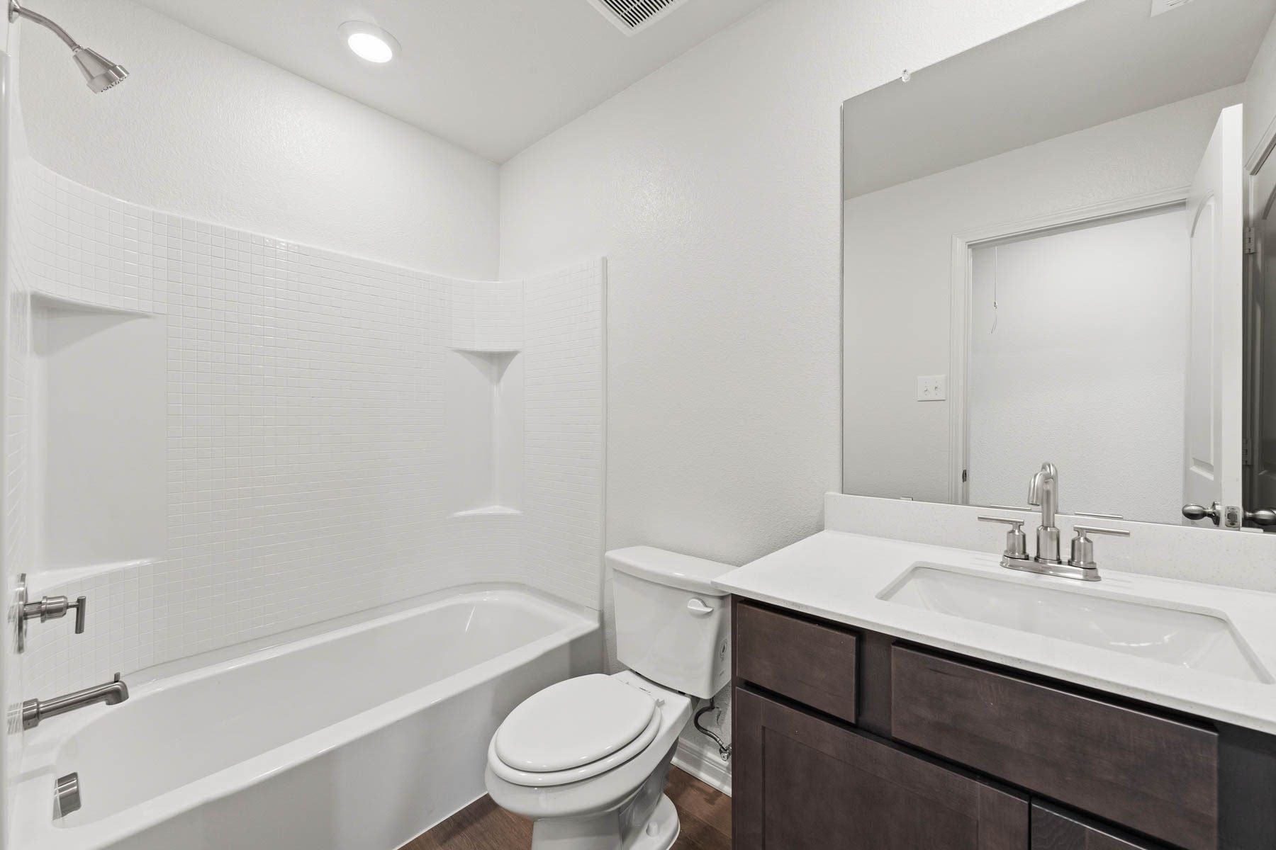 The secondary bathoom has a large vanity space and shower-tub combo.