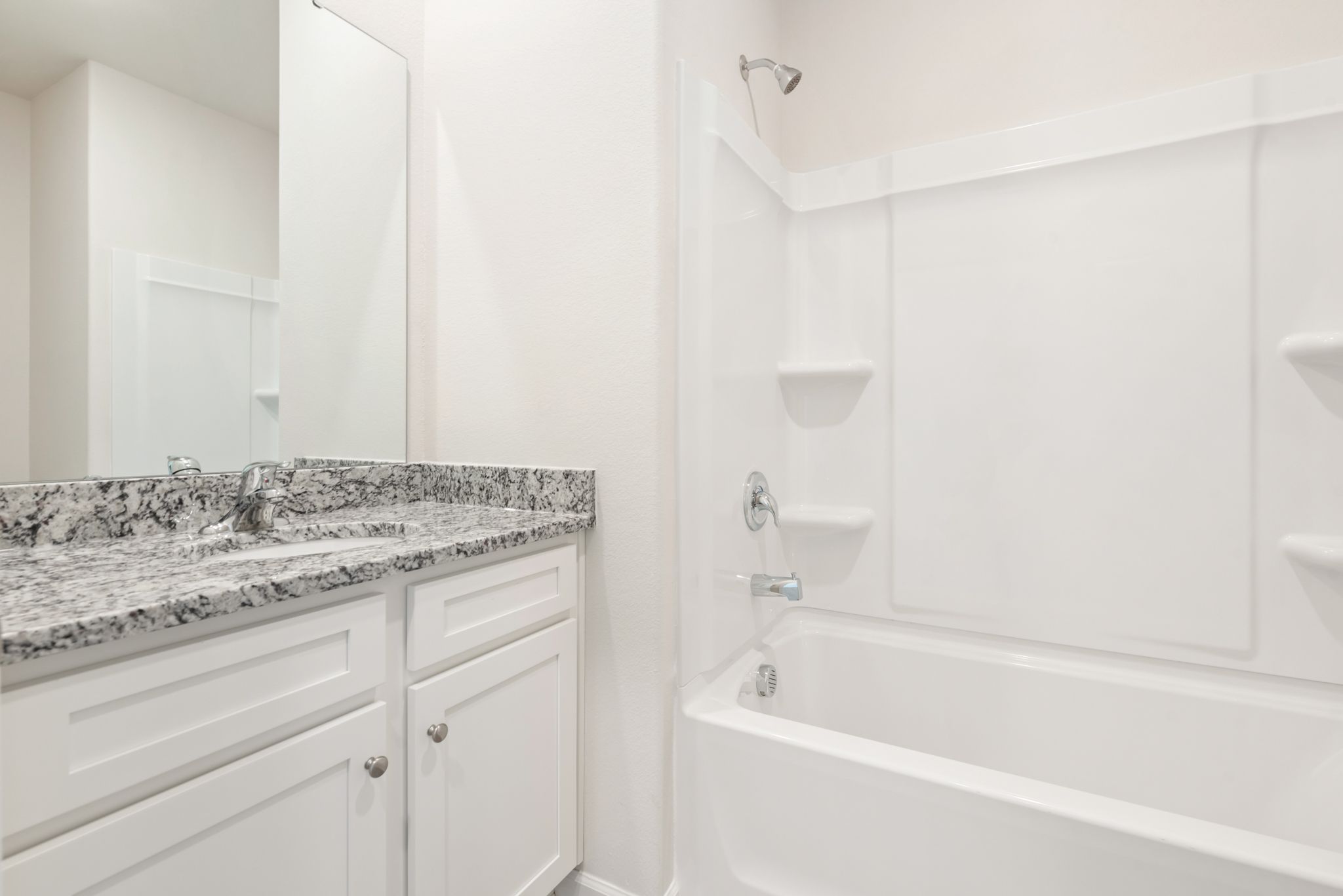 This bathroom has granite countertops and a large soaking tub