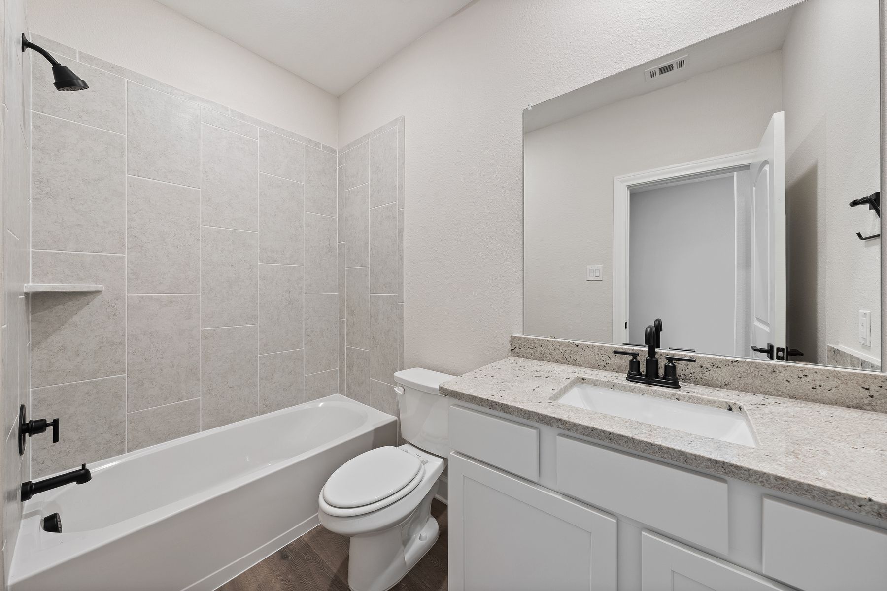 The secondary bathroom of the Sabine floor plan has a vanity space and a shower-tub combo.