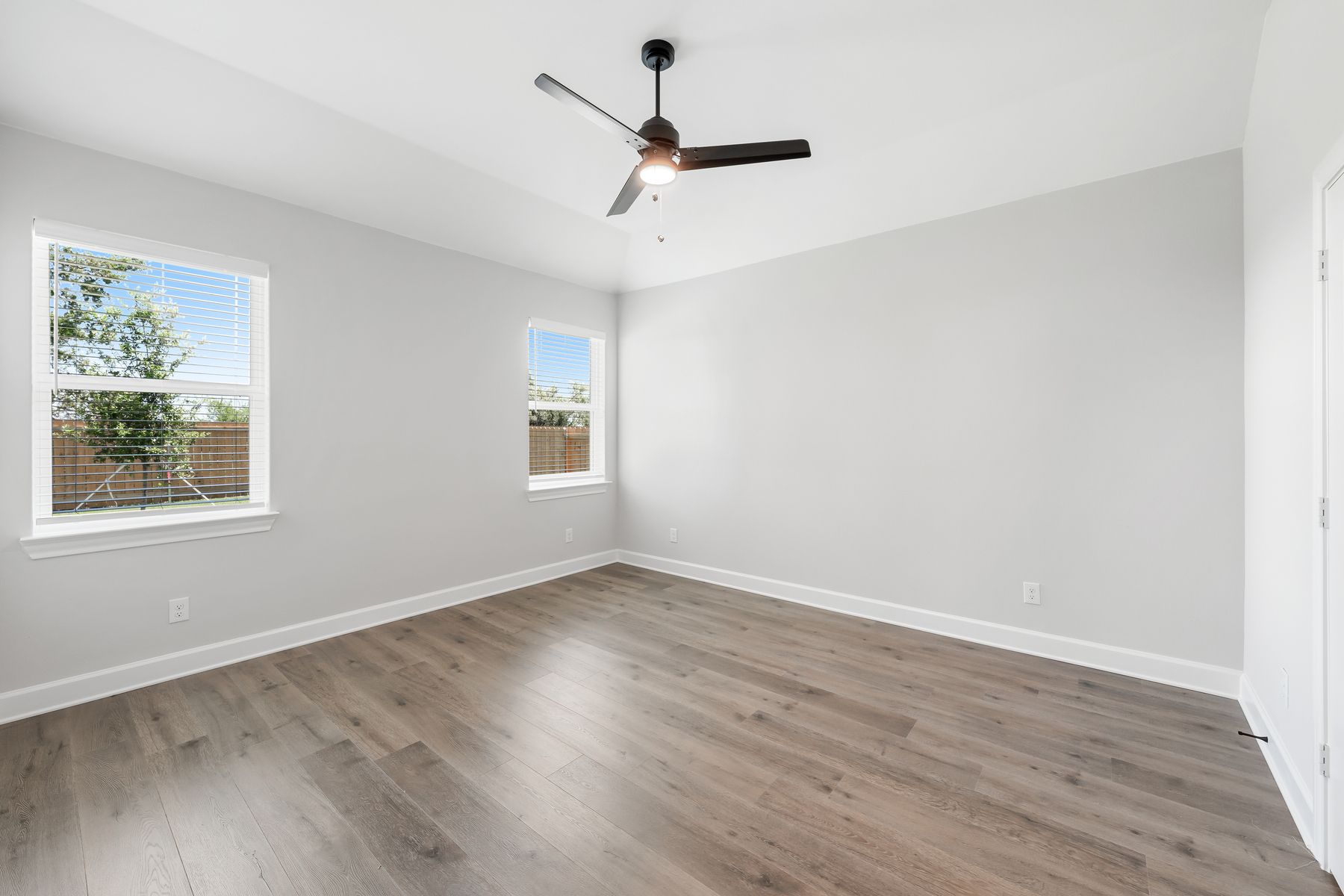 The spacious master bedroom has two large windows that let in great, natural light and backyard views.