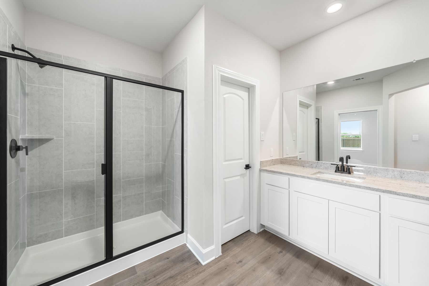 The master bathroom of the Reed has a large vanity space and glass, walk-in shower.