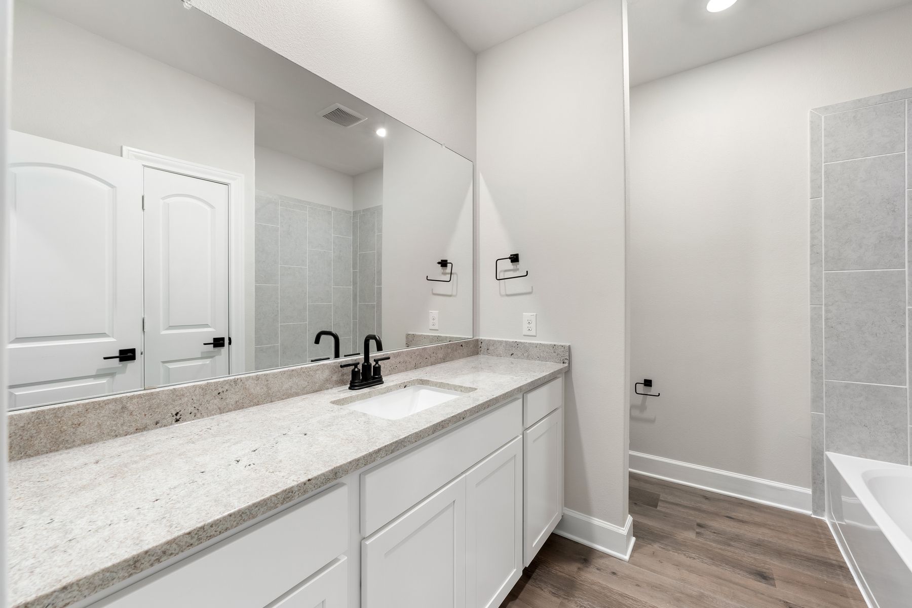The secondary bathroom has a large vanity with plenty of counterspace and a shower-tub combo.