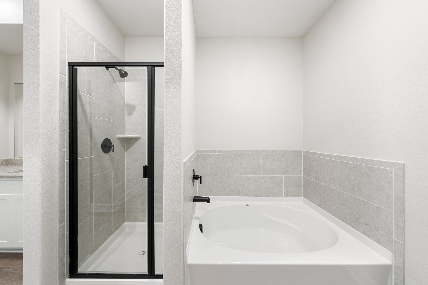 The master bathroom of the Driftwood has a glass, walk-in shower and large garden tub.
