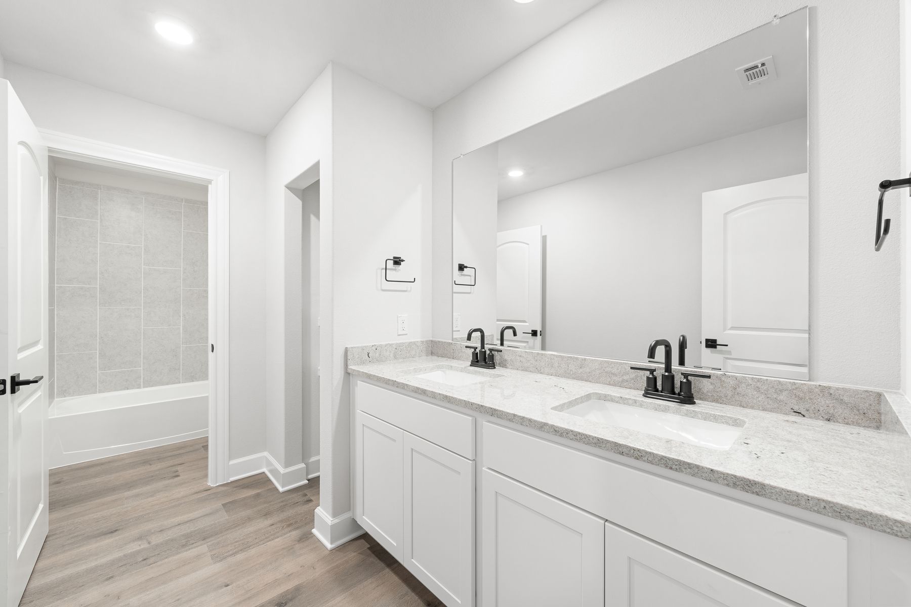 The secondary bathroom of the Driftwood has a large vanity space and shower-tub combo.