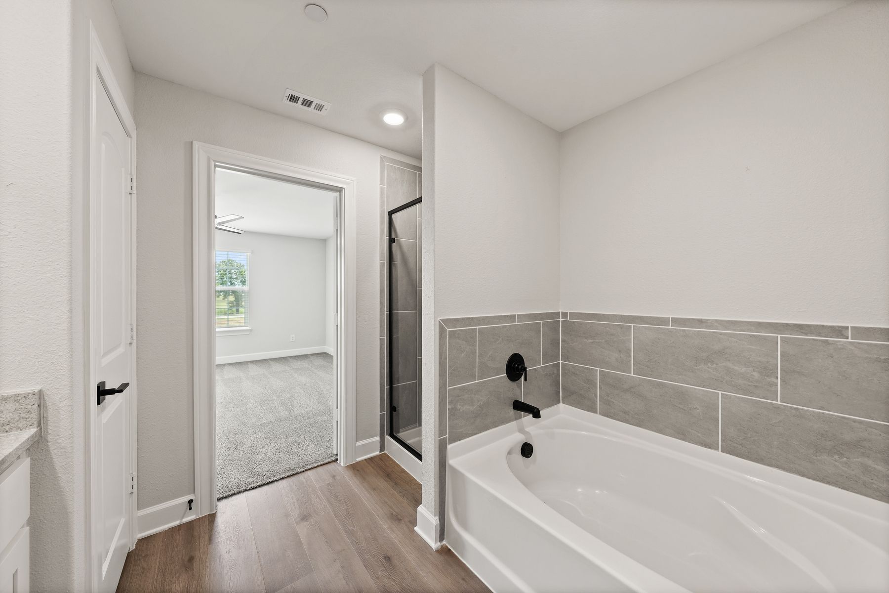The master bathroom has a large glass, walk-in shower and garden tub.