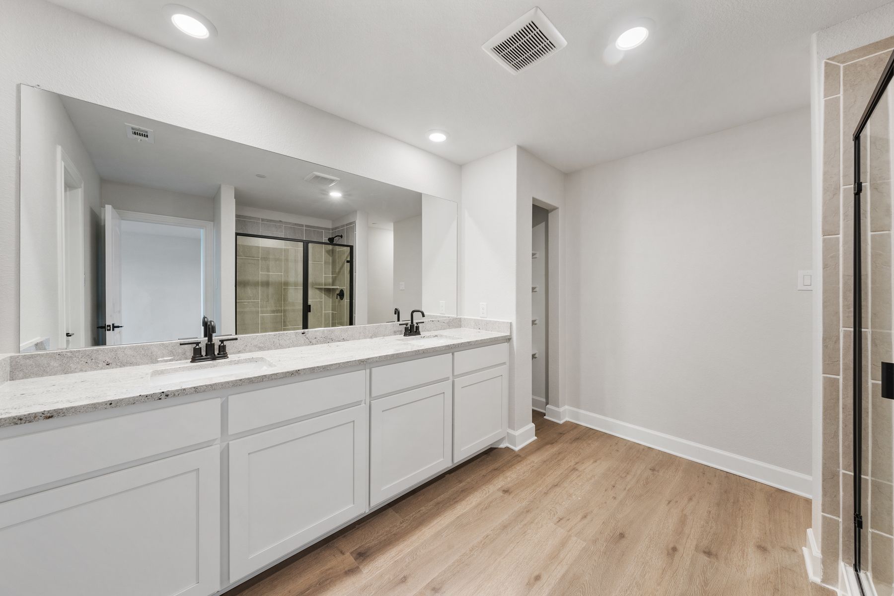 The master bathroom has a large vanity space, garden tub and glass, walk-in shower.
