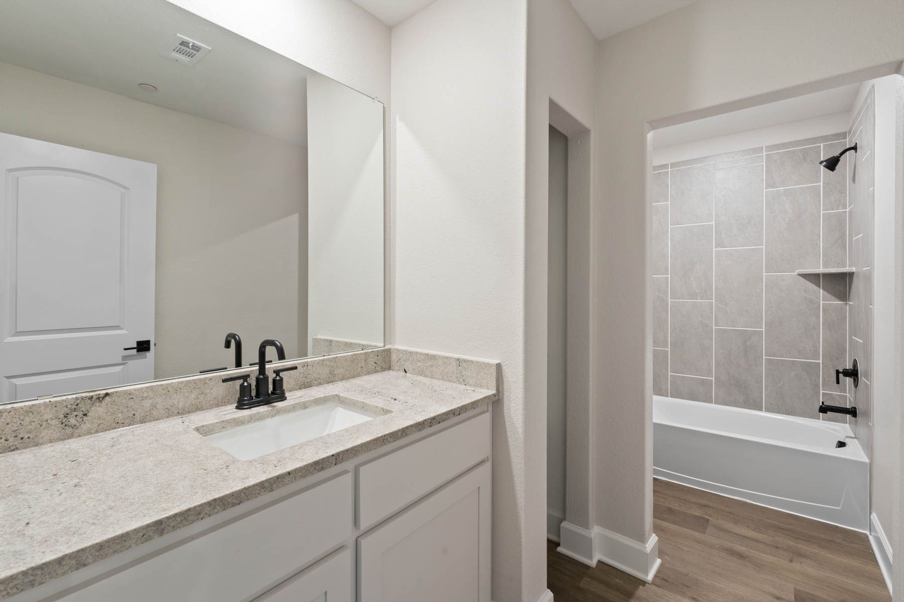 The secondary bathroom of the Noma has a large vanity space and a shower-tub combo.
