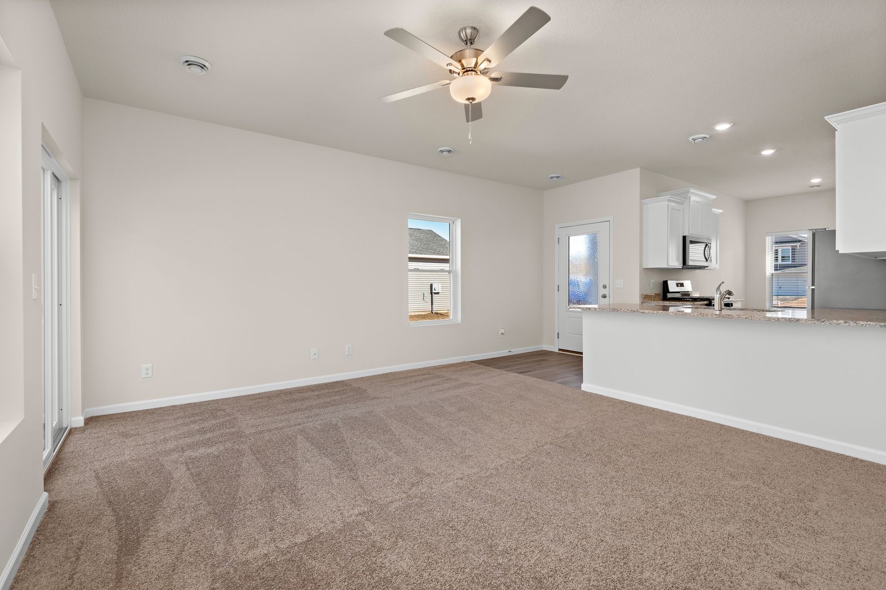 The family room is spacious with a ceiling fan.