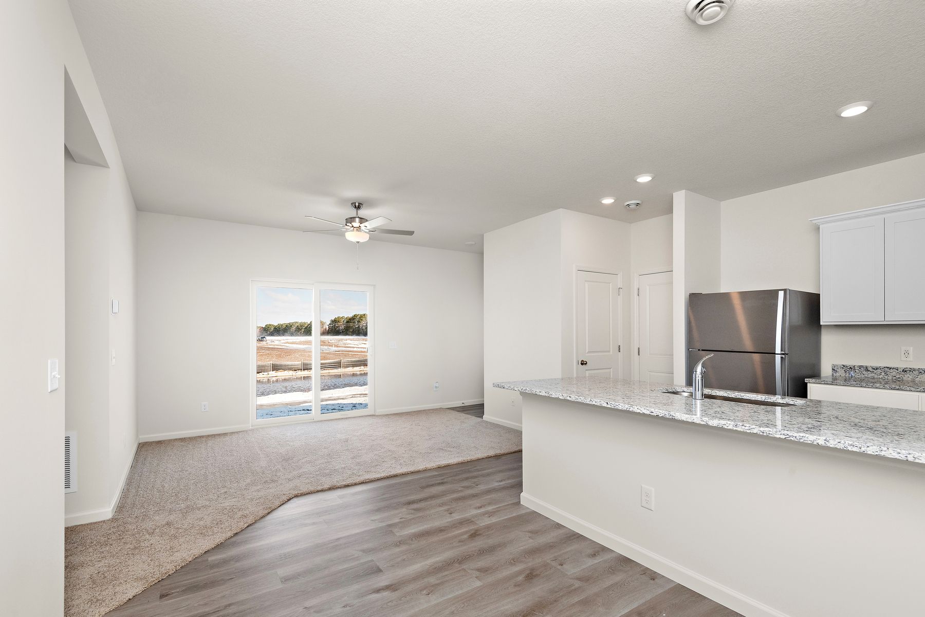 The family room is spacious with a ceiling fan.