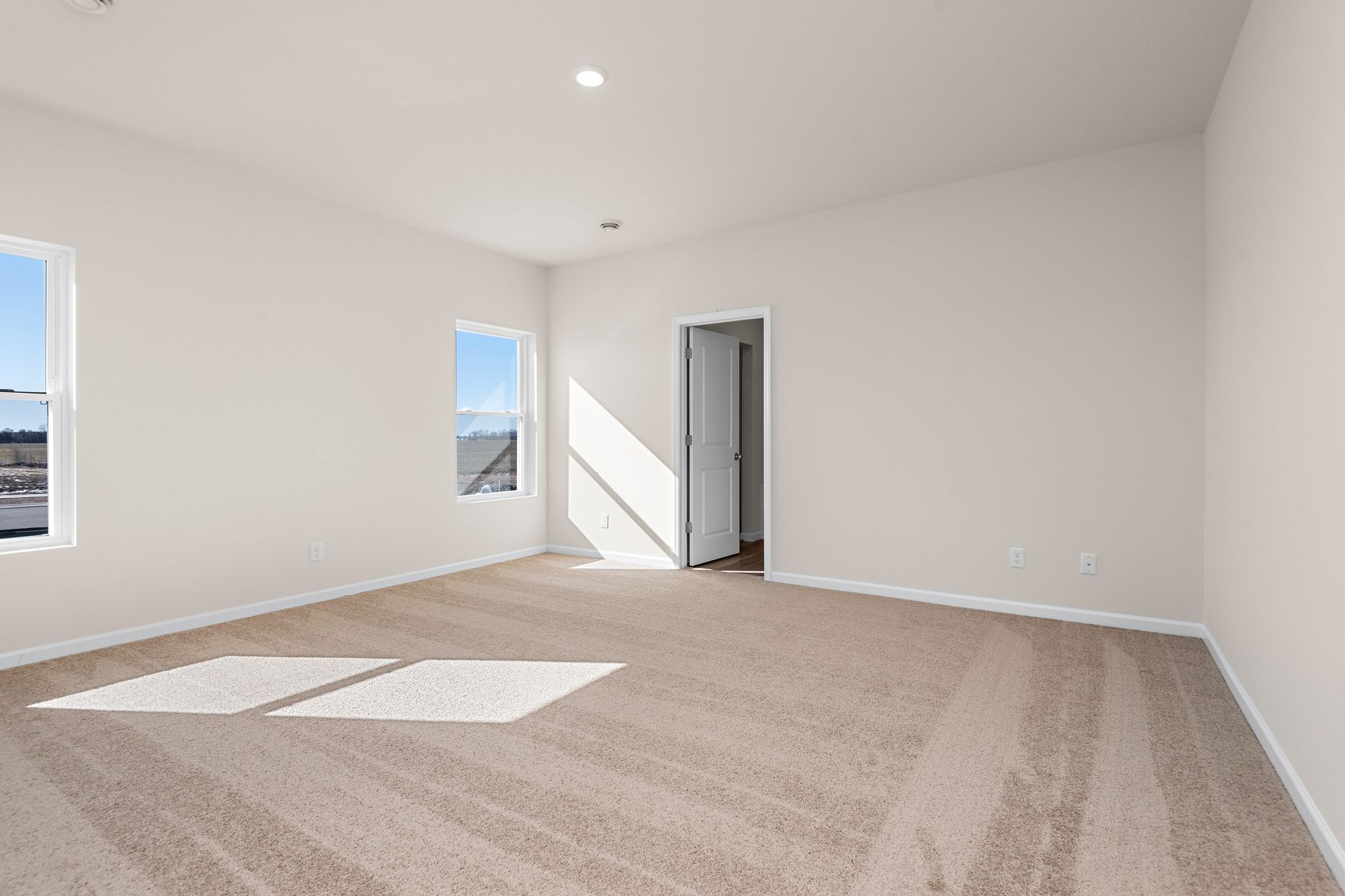 The master bedroom is spacious and has carpet.