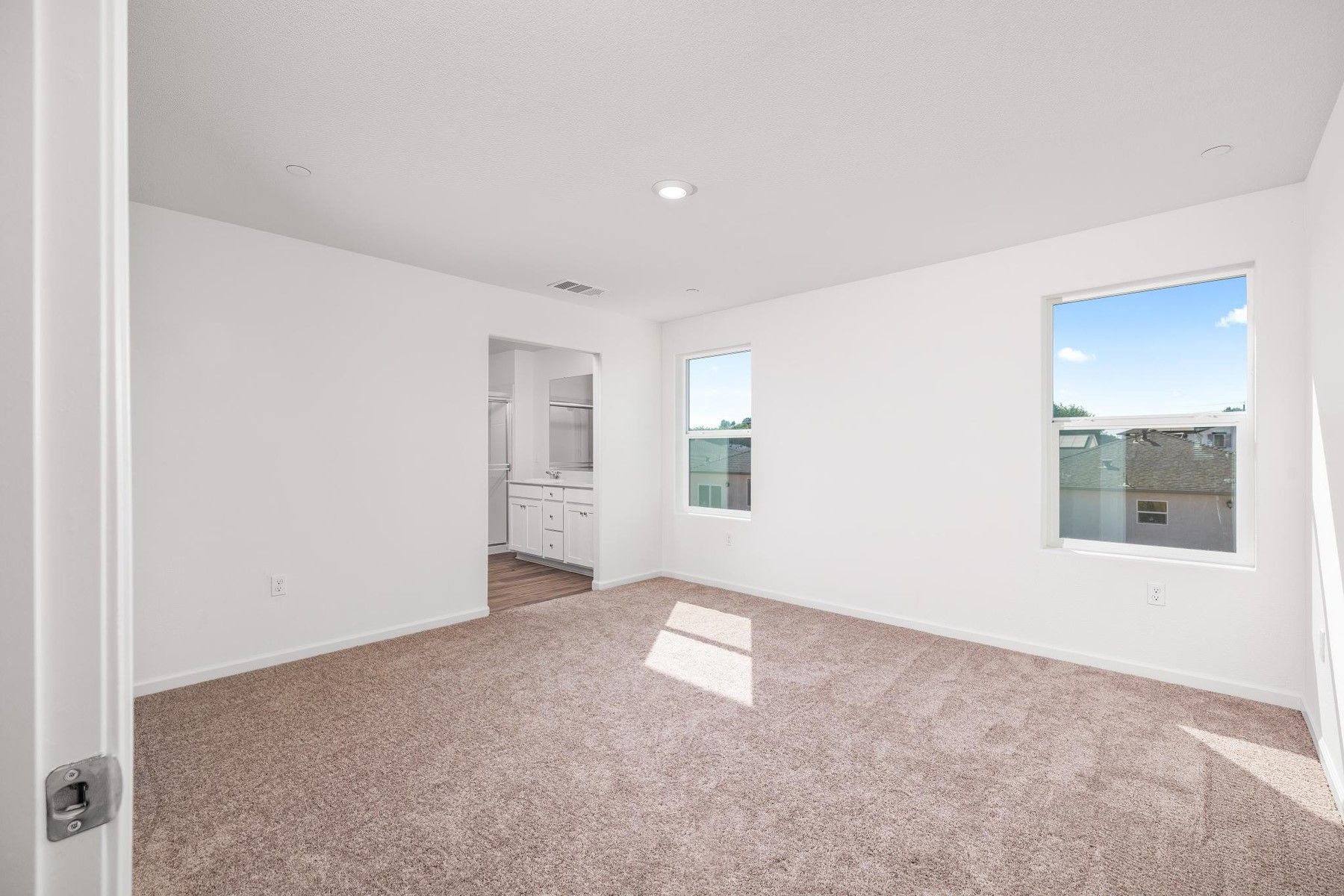 The master bedroom is spacious and has carpet.