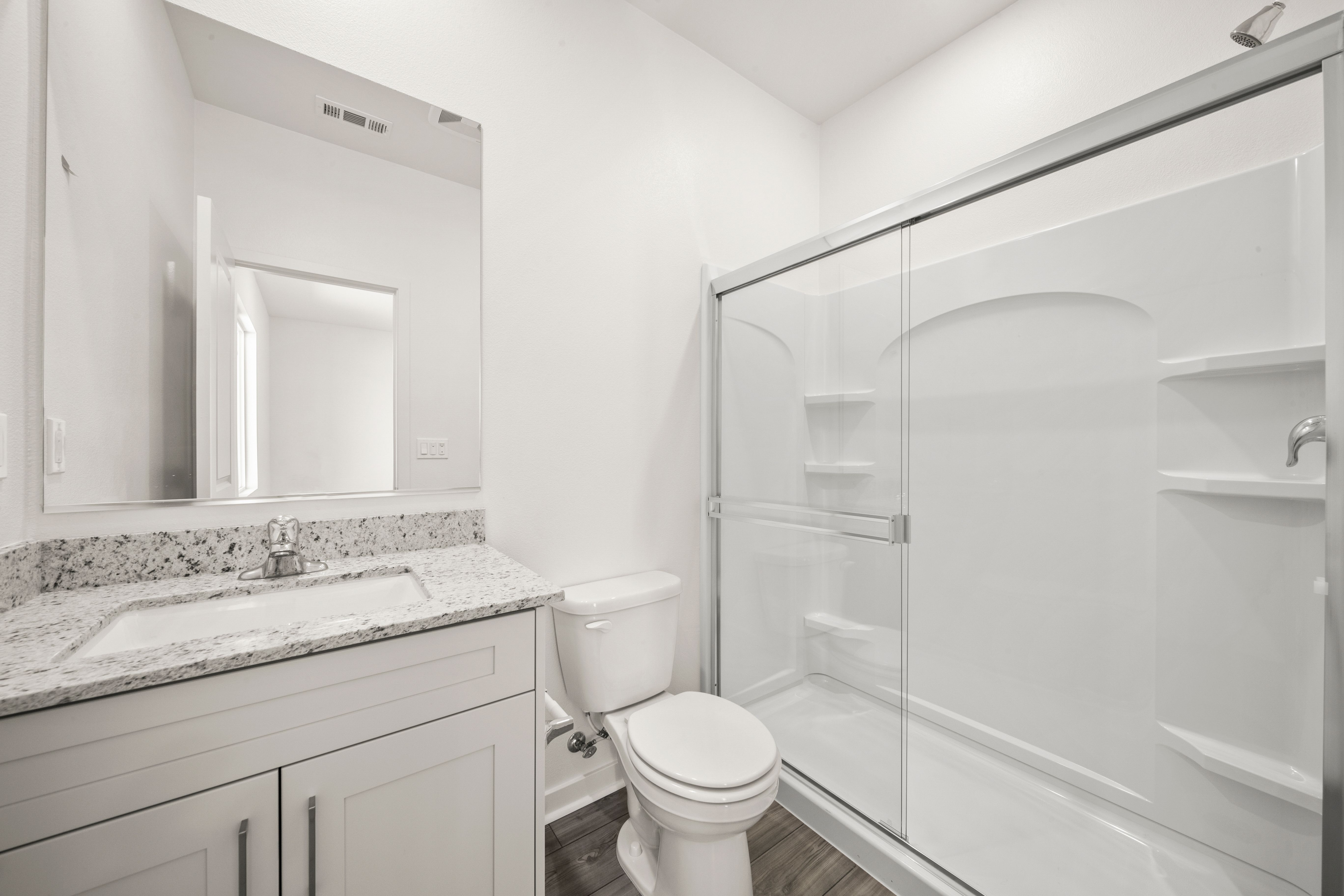 The master bathroom has a large vanity and a step in shower.