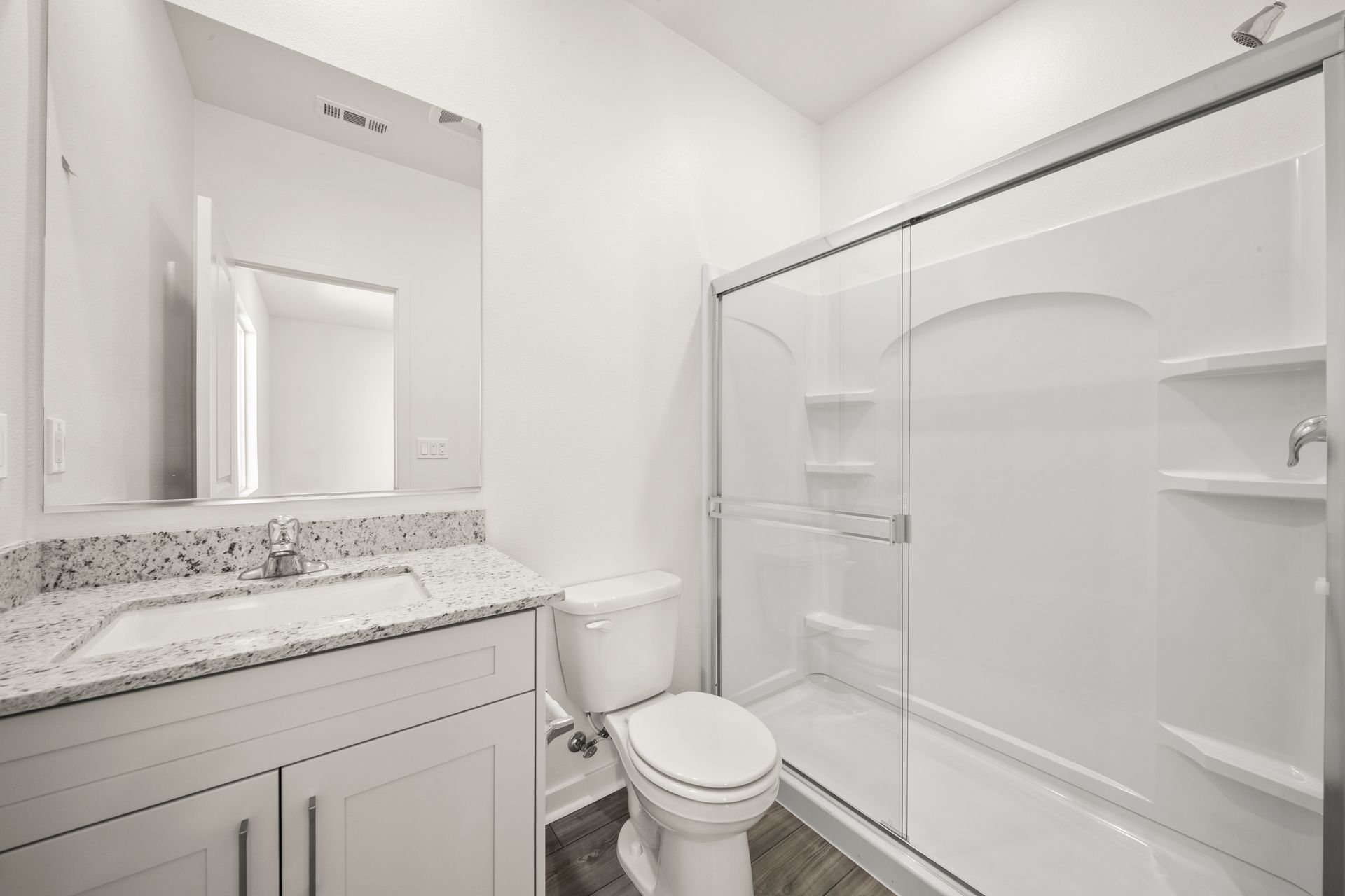 The master bathroom has a large vanity and a step in shower.