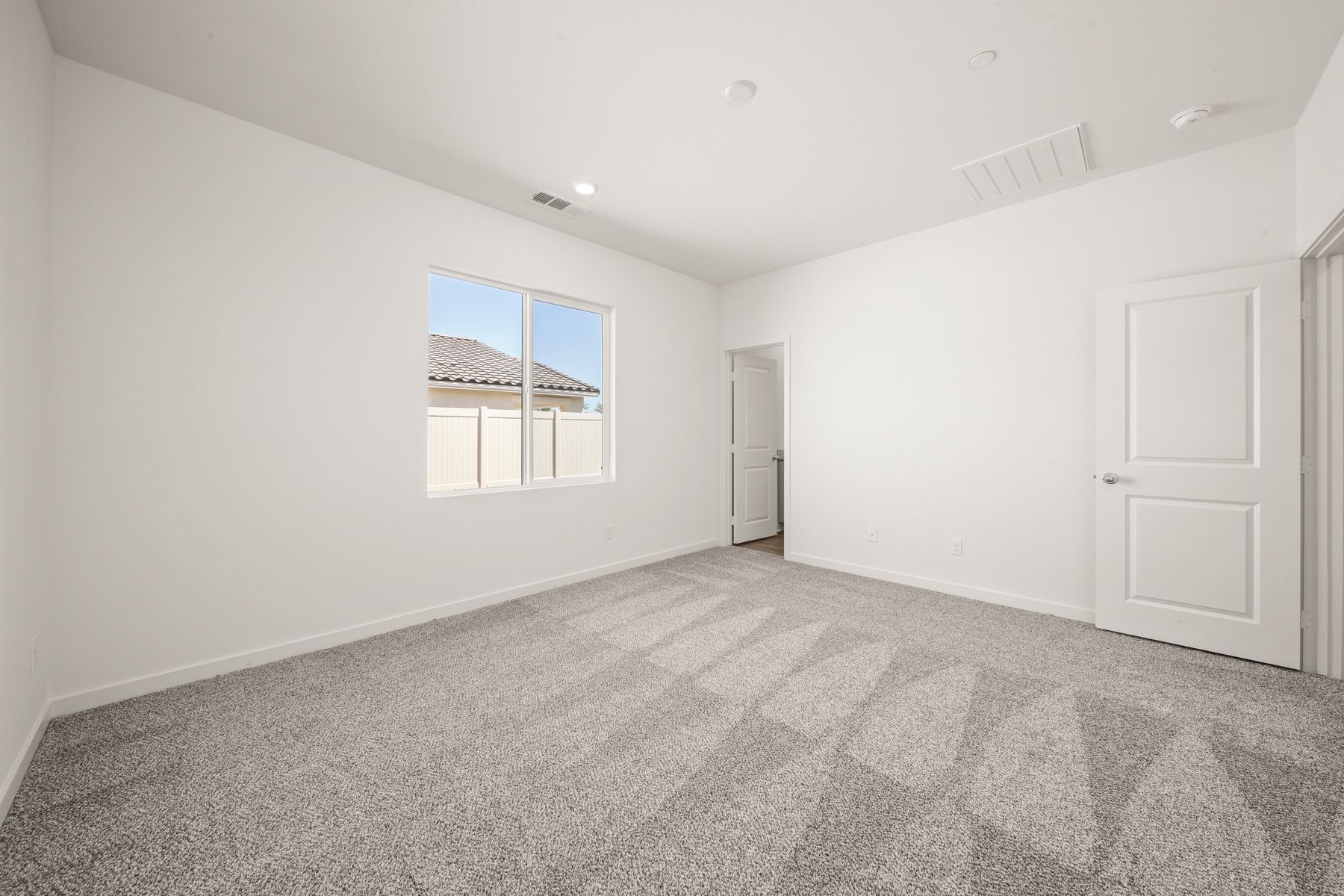 The master bedroom is spacious and has carpet.