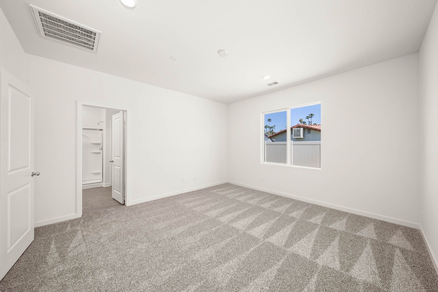 The master bedroom is spacious and has carpet.