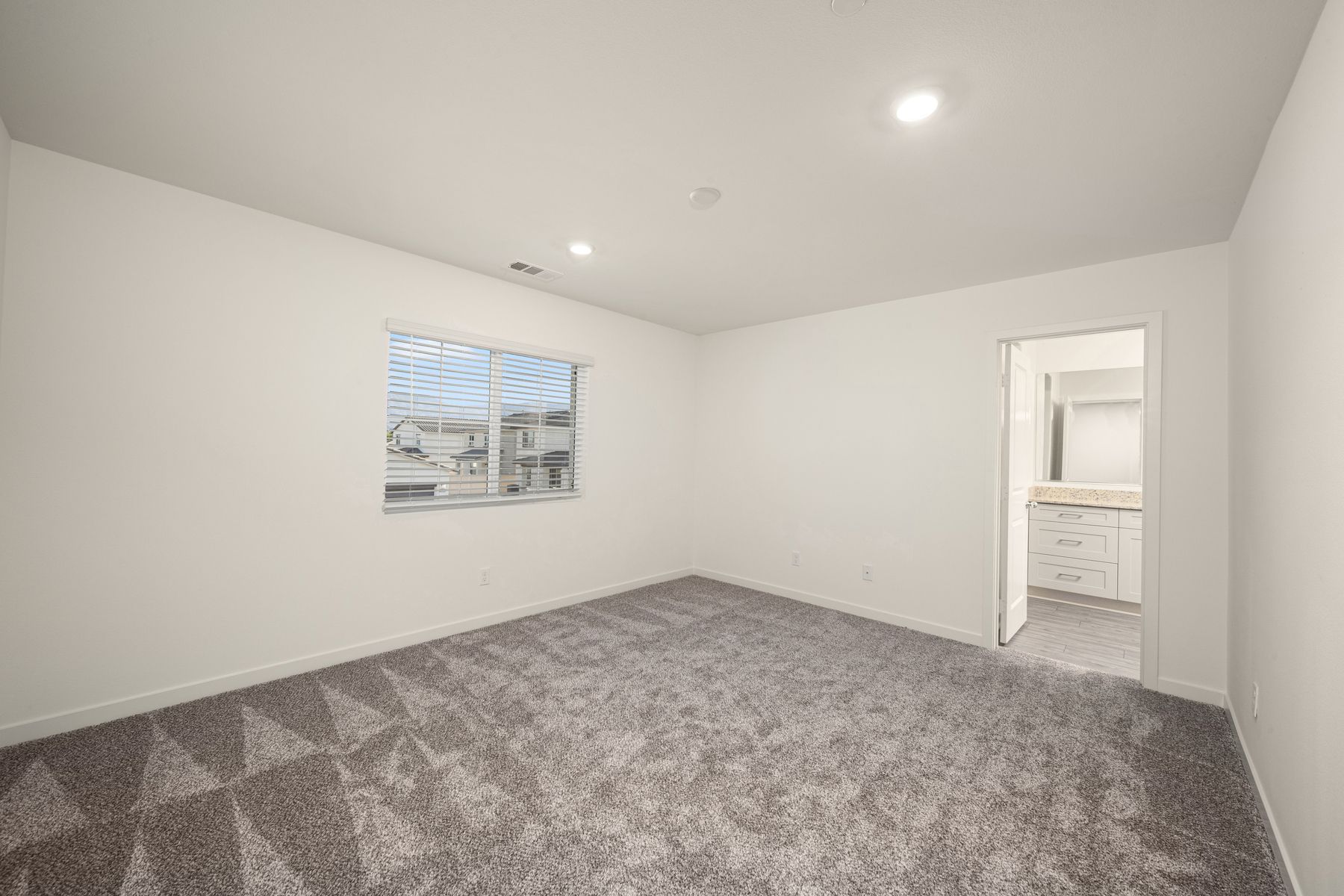 The master bedroom is spacious and has carpet.