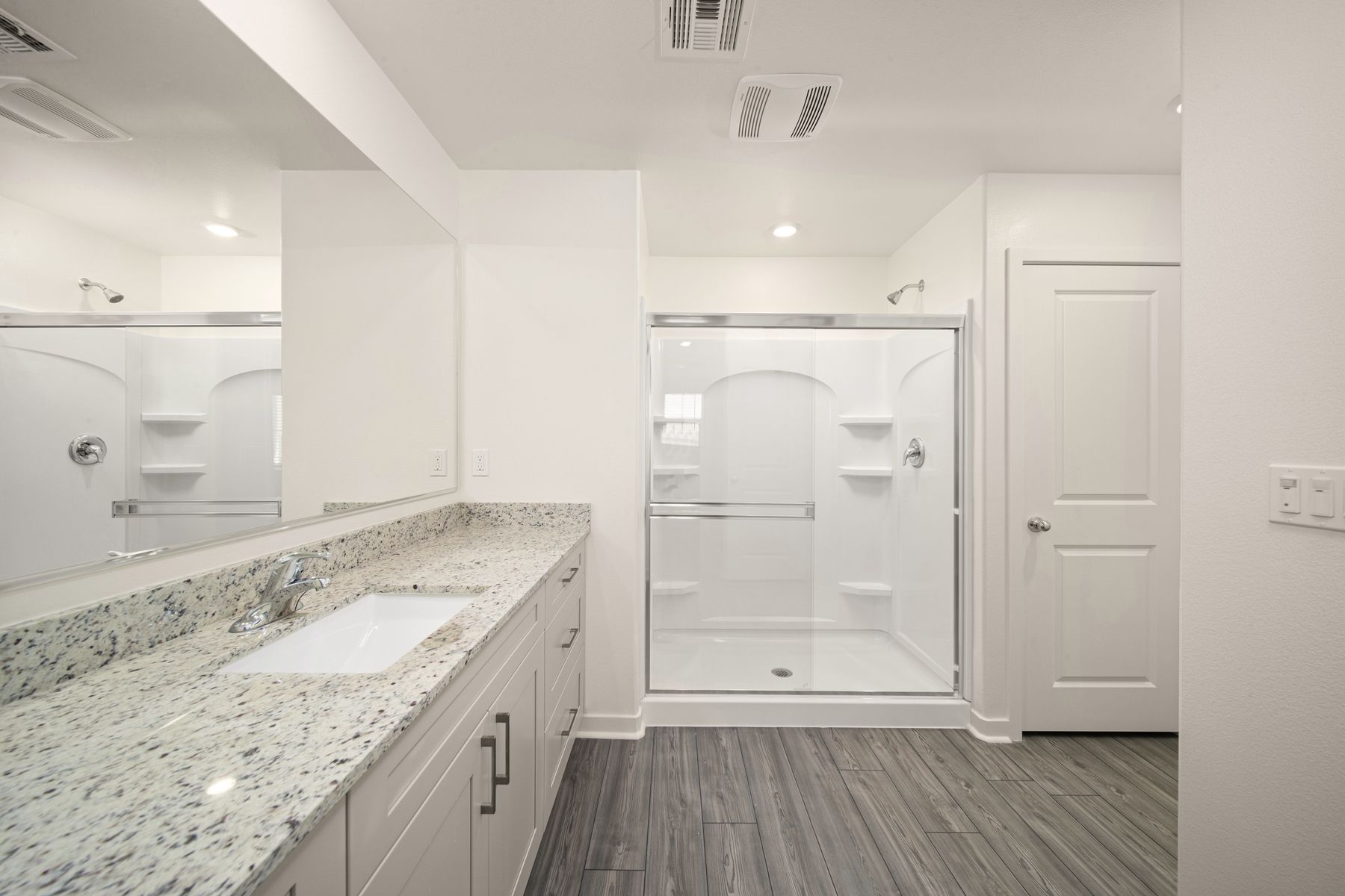 The master bathroom has a large vanity with a step in shower.