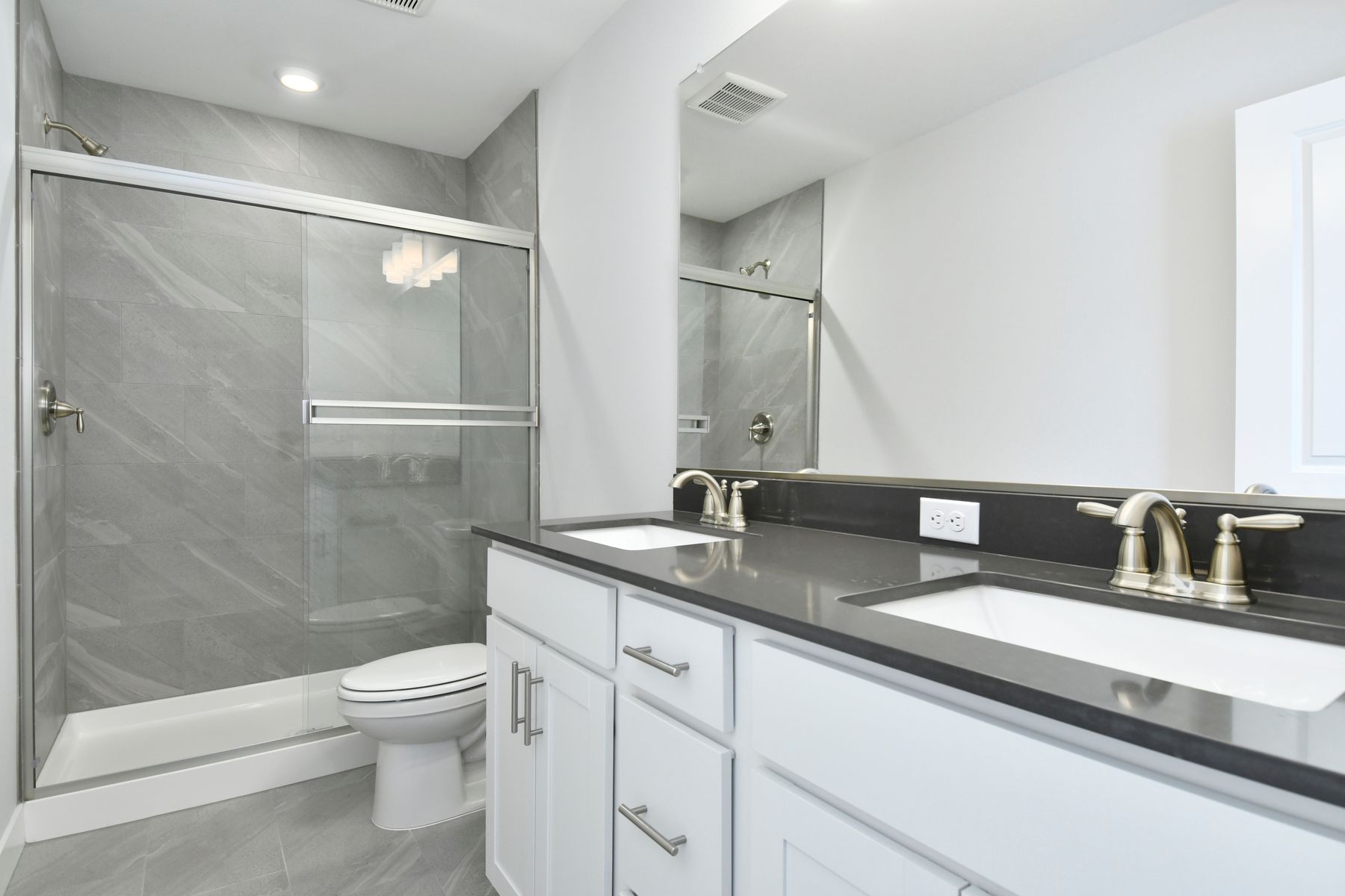 The master bathroom has a large vanity and a step in shower.