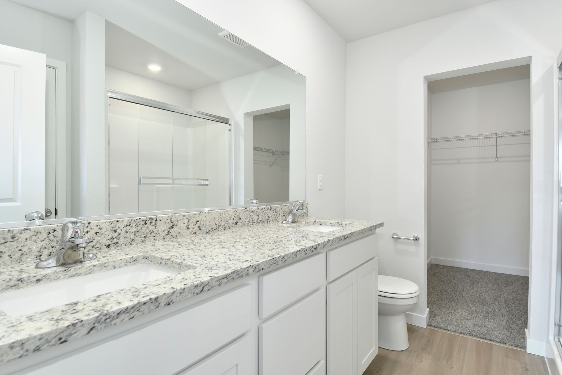 The master bathroom has a dual sink vanity and a step in shower.