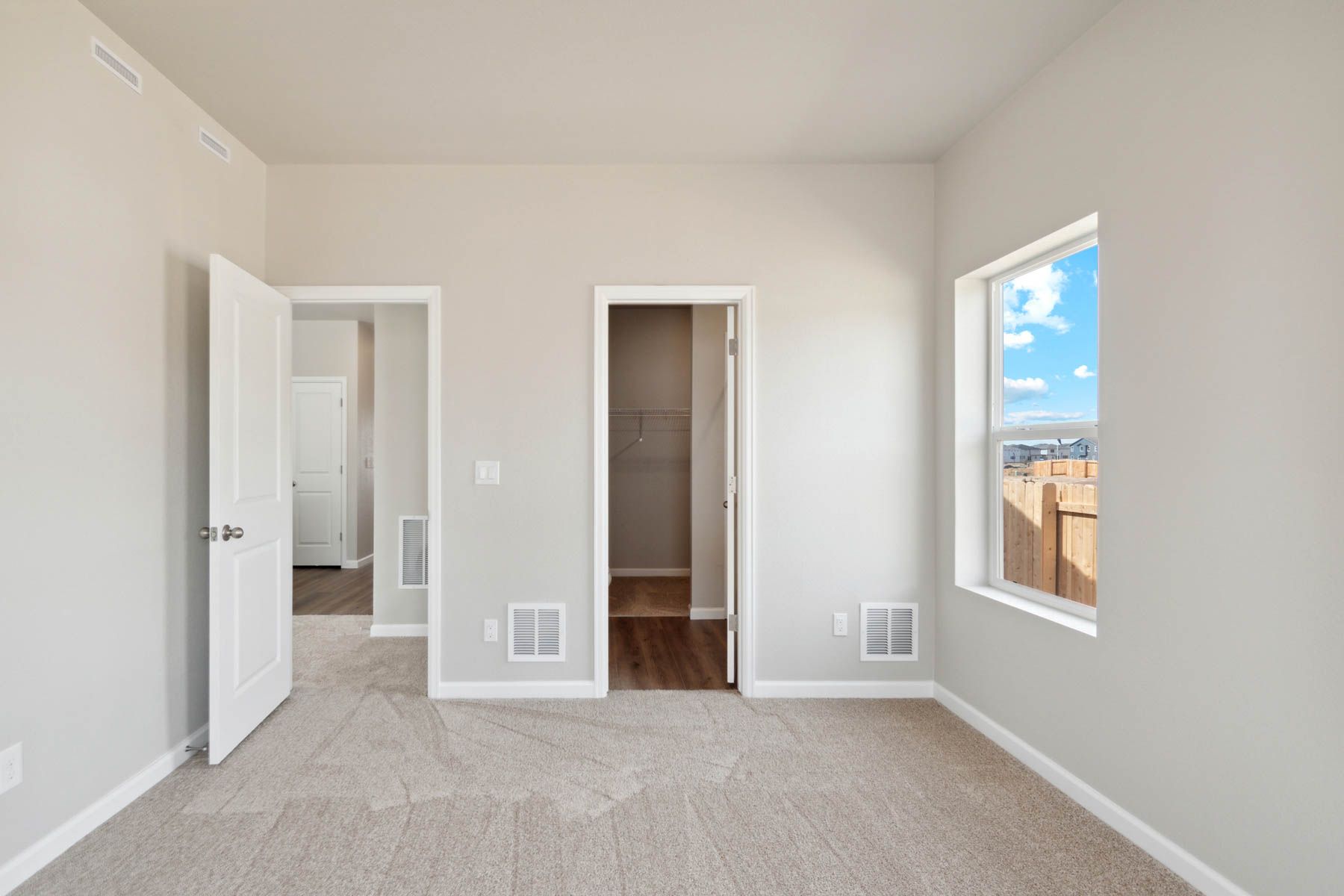 The master bedroom is spacious and has carpet.