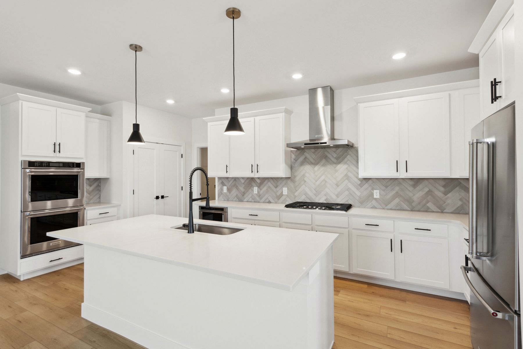 The kitchen has beautiful white wood cabinets with black hardware.