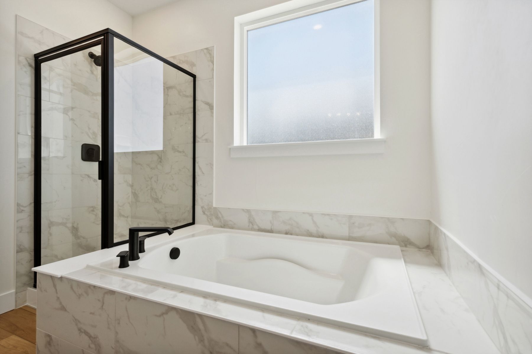 The master bathroom has a large glass, walk-in shower and garden tub.