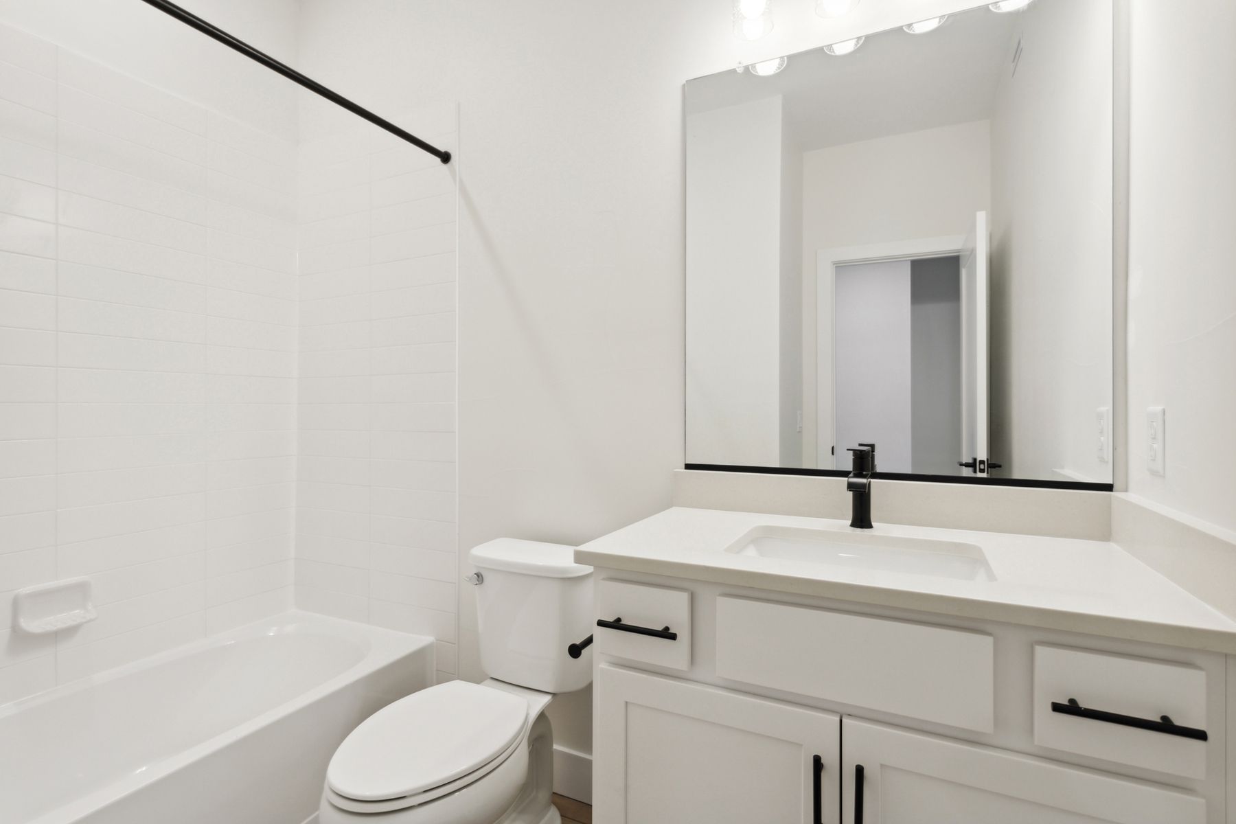 The secondary bathroom has a spacious vanity and shower-tub combo.