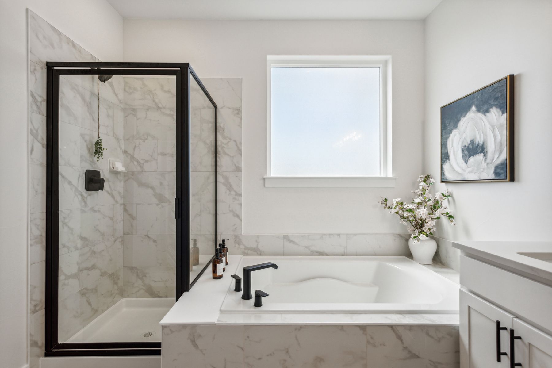 The master bathroom has a large garden tub and a glass, walk-in shower.