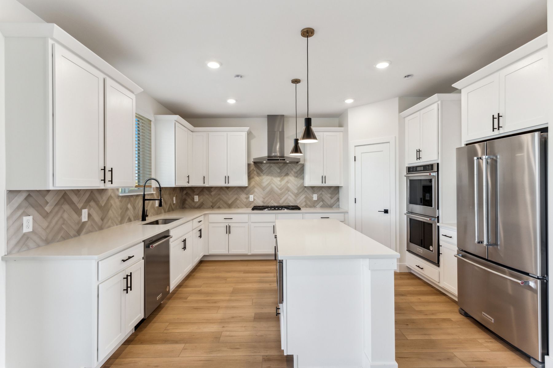 The kitchen has white wood cabinetry with black hardware.