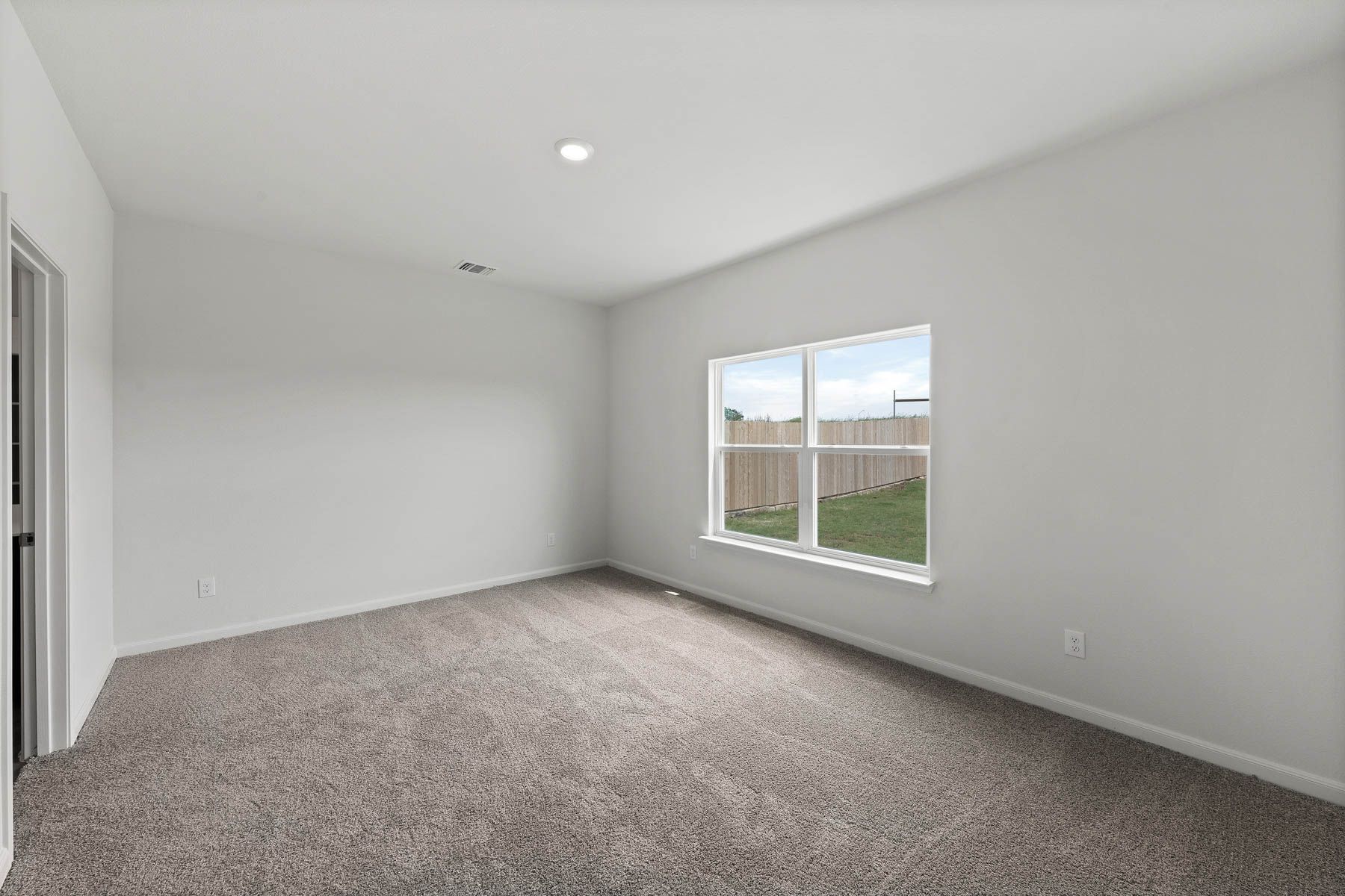 The master bedroom of the Driftwood has a large window that lets in great natural light and backyard views.