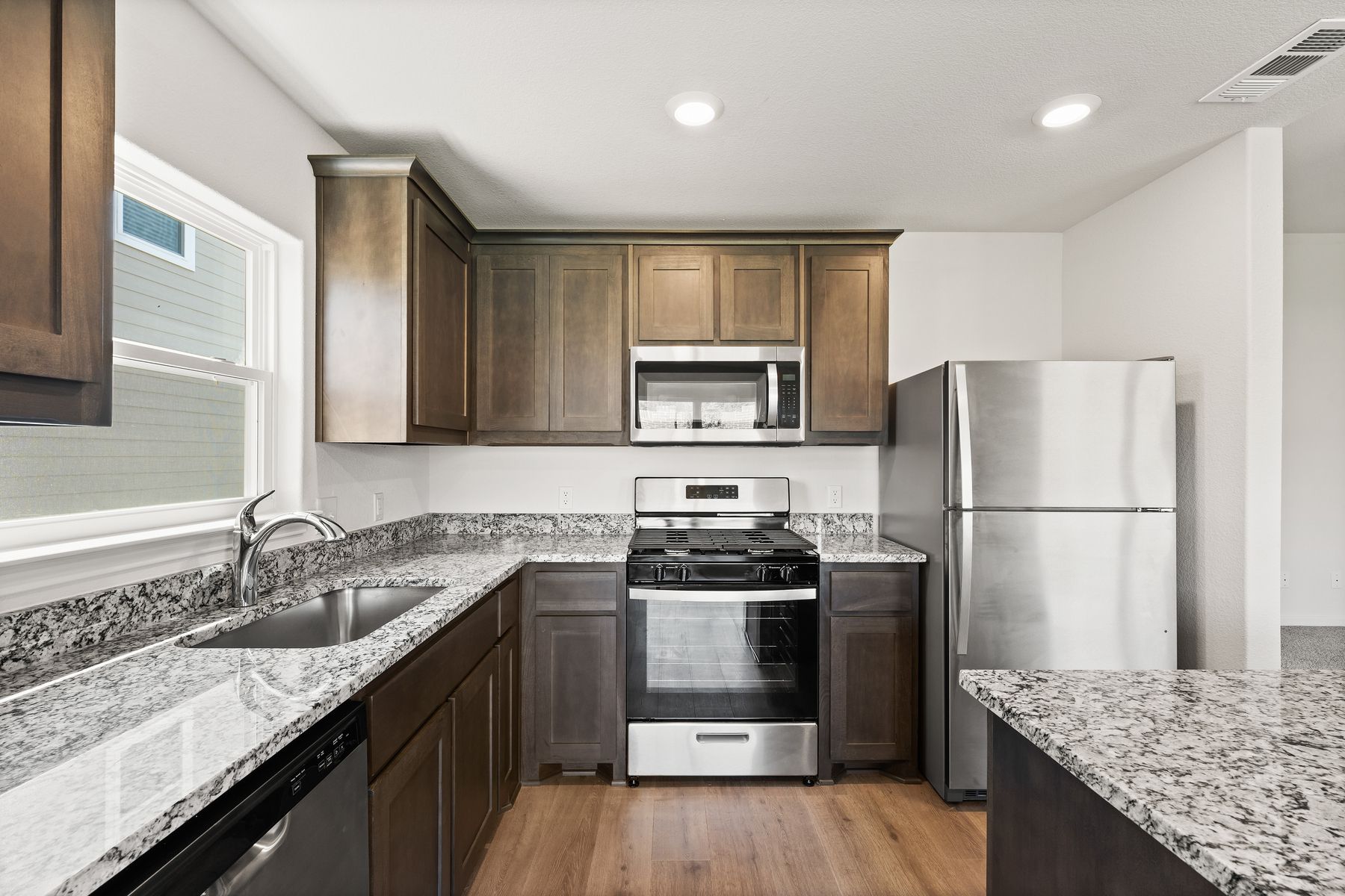 The upgraded kitchen has sprawling granite countertops.