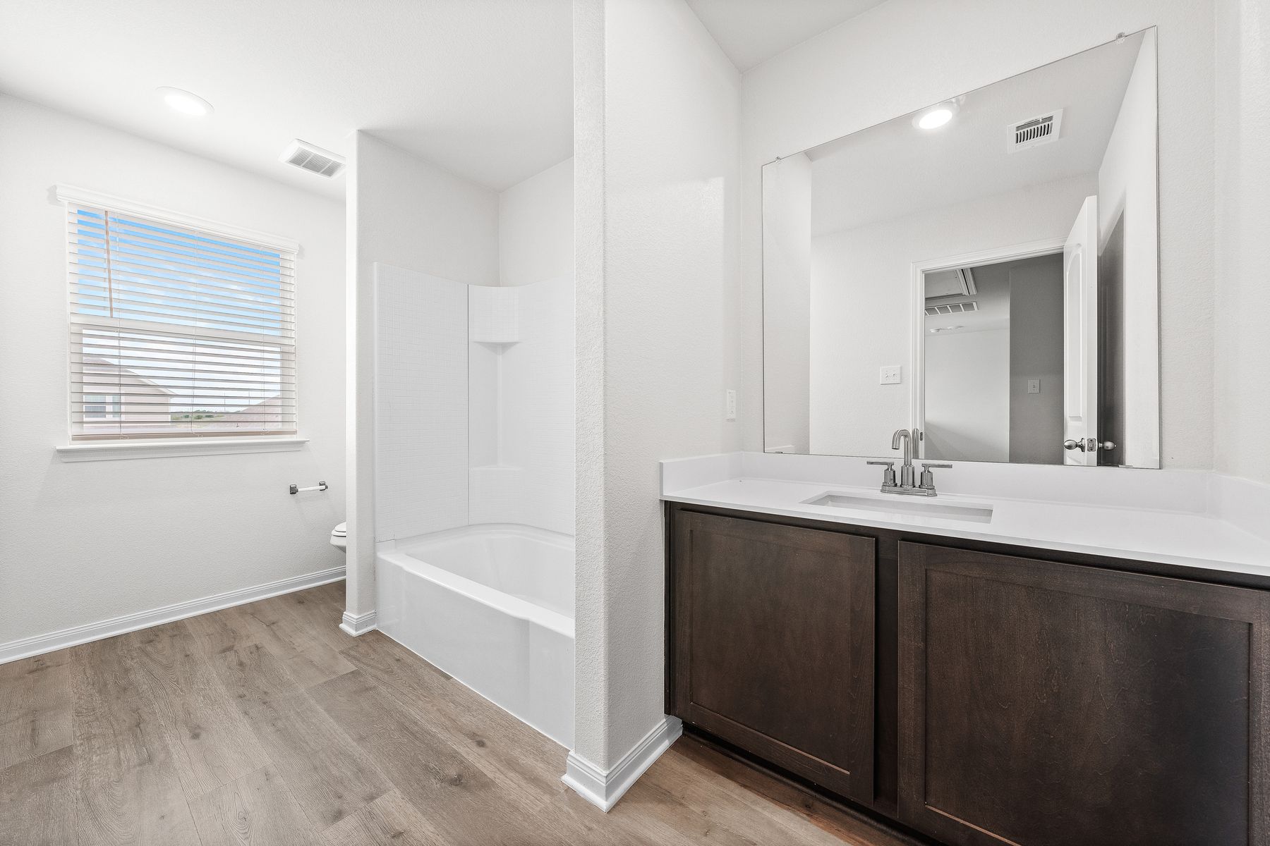 The secondary bathroom of the Cypress has a large vanity and shower-tub combo.