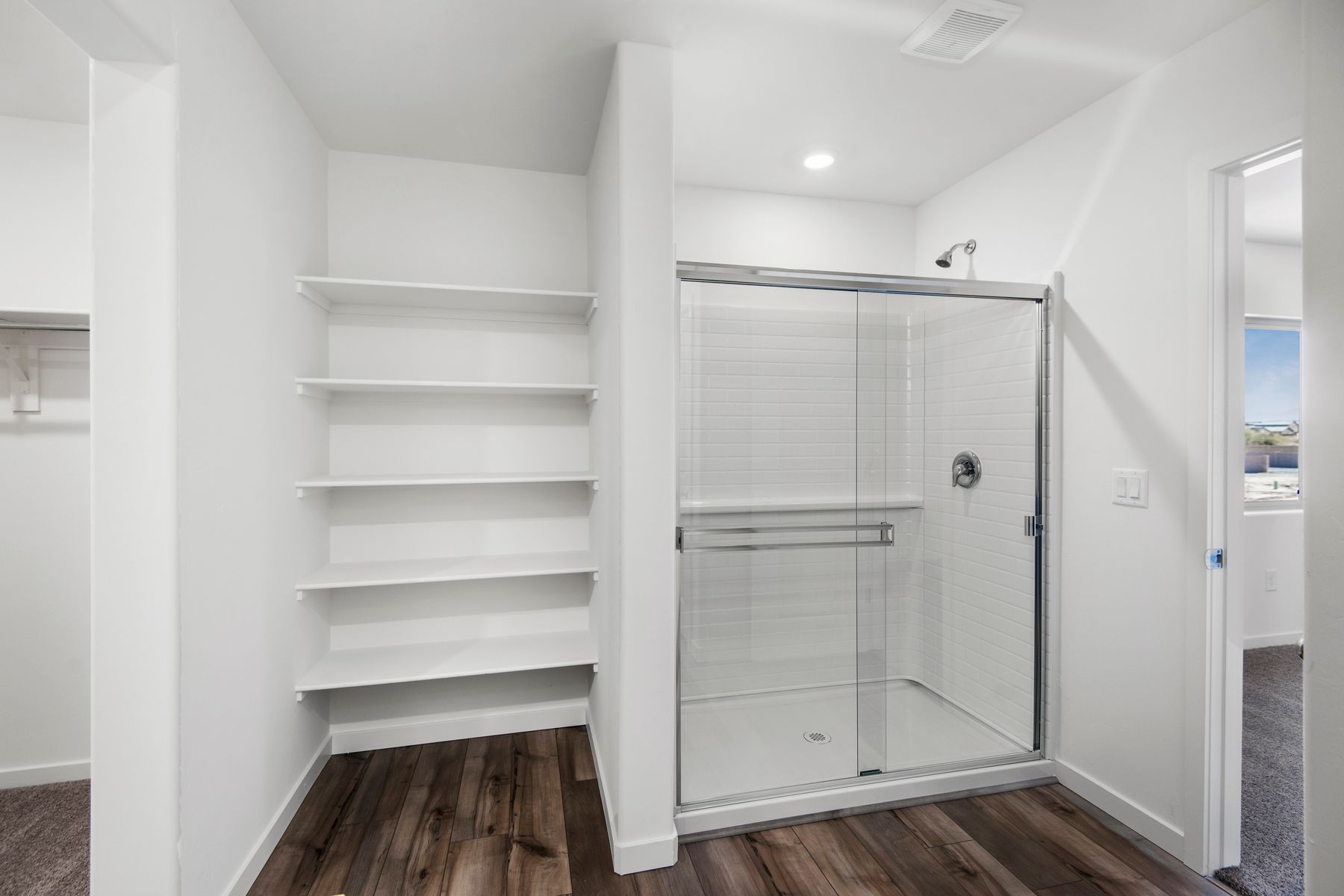 The master bathroom provides plenty of space with built in shelving and a walk in shower.
