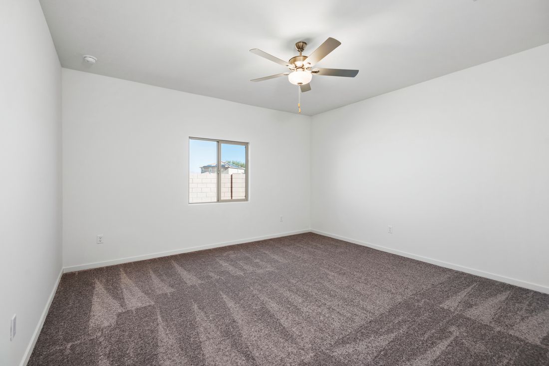 The master bedroom is beautifully lit by natural sunlight.
