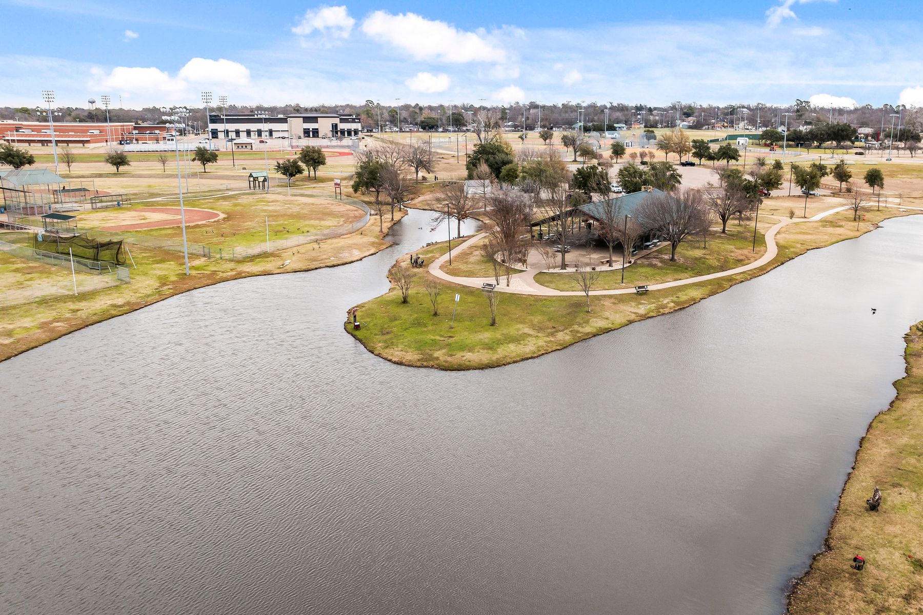 Overview of the beautiful Ben Gill Park with sports fields and courts, playgrounds, a pool and a beautiful pond.