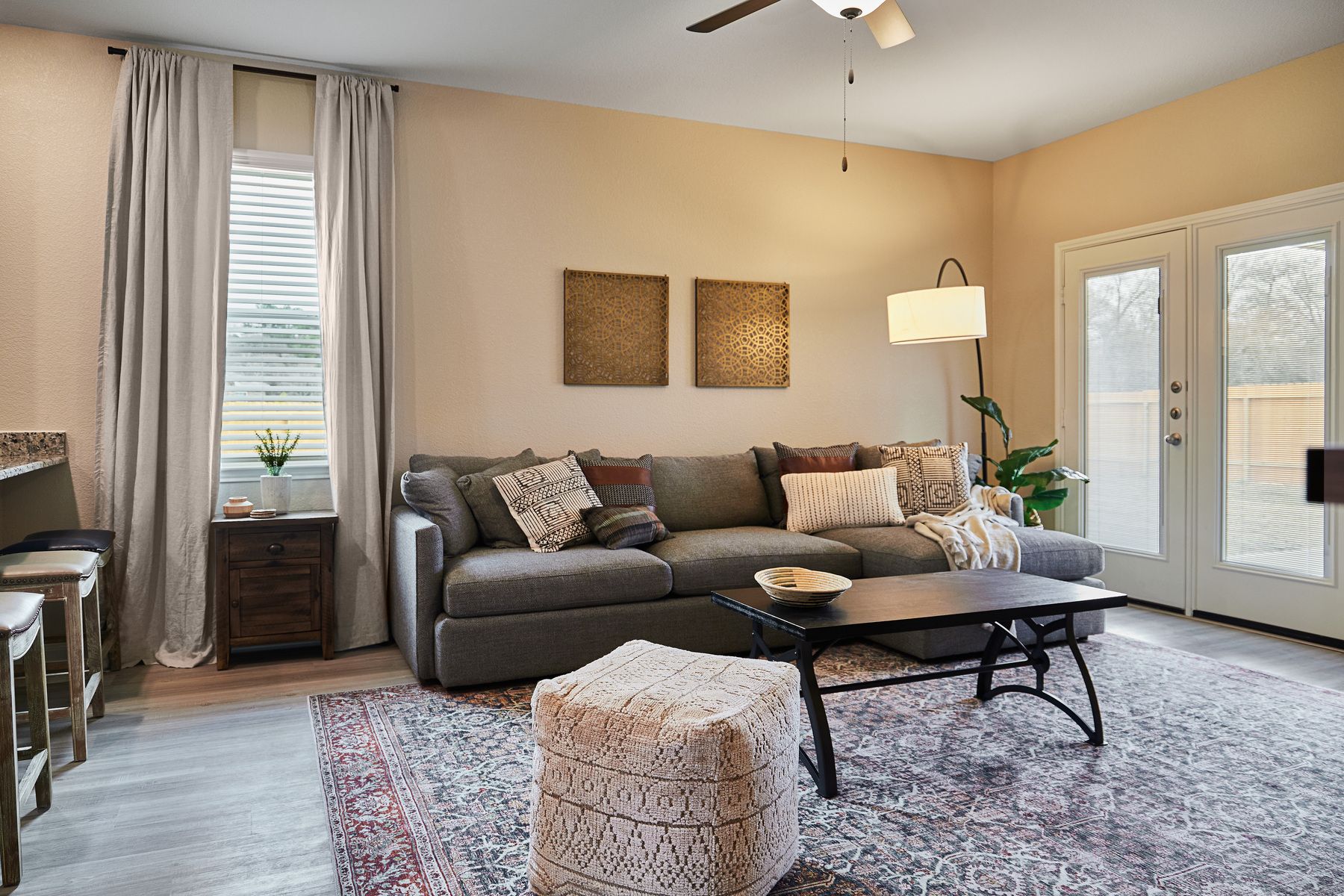 Staged living room with a gray couch and standing lamp.