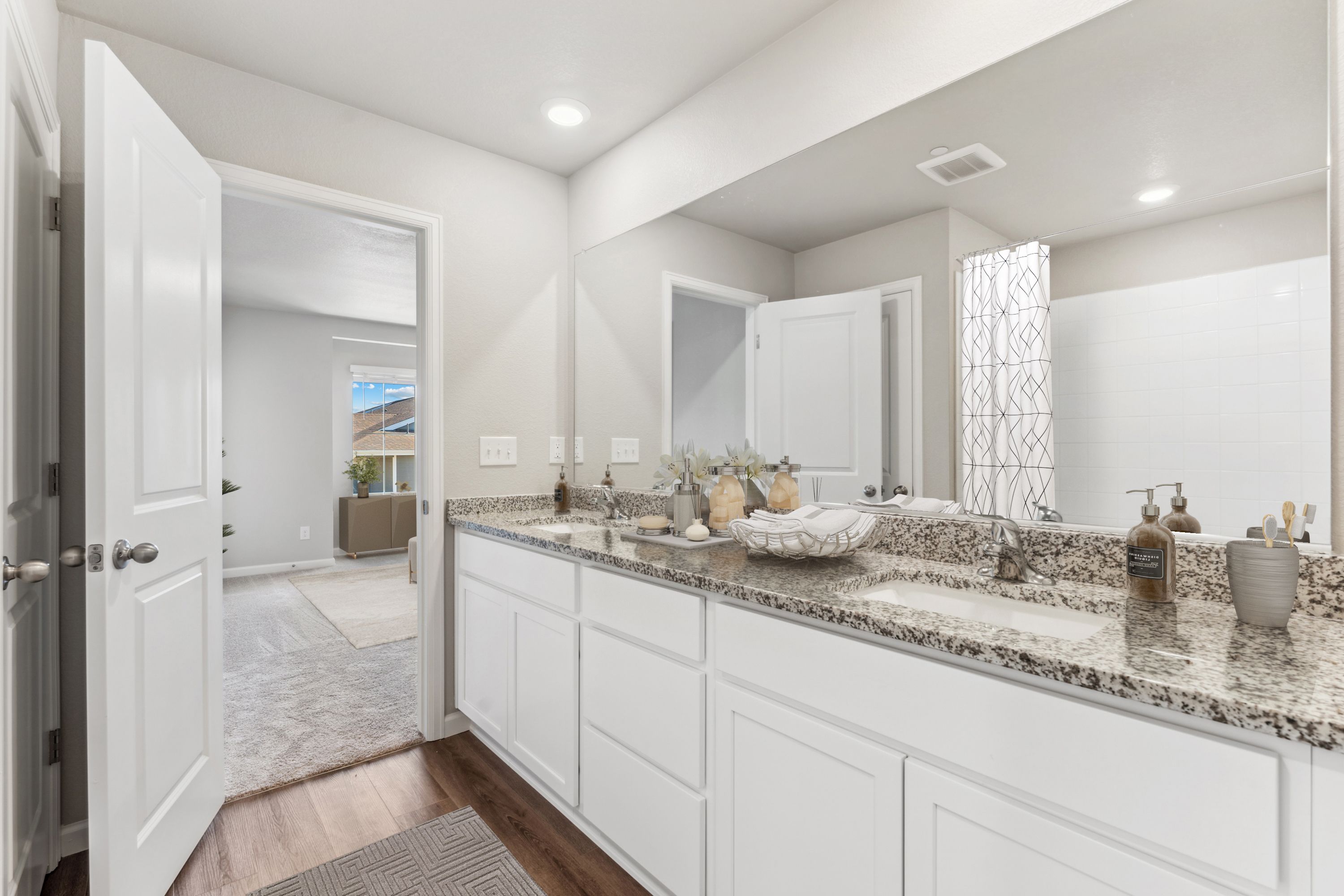 The master bathroom has a dual sink vanity and tub/shower combo.