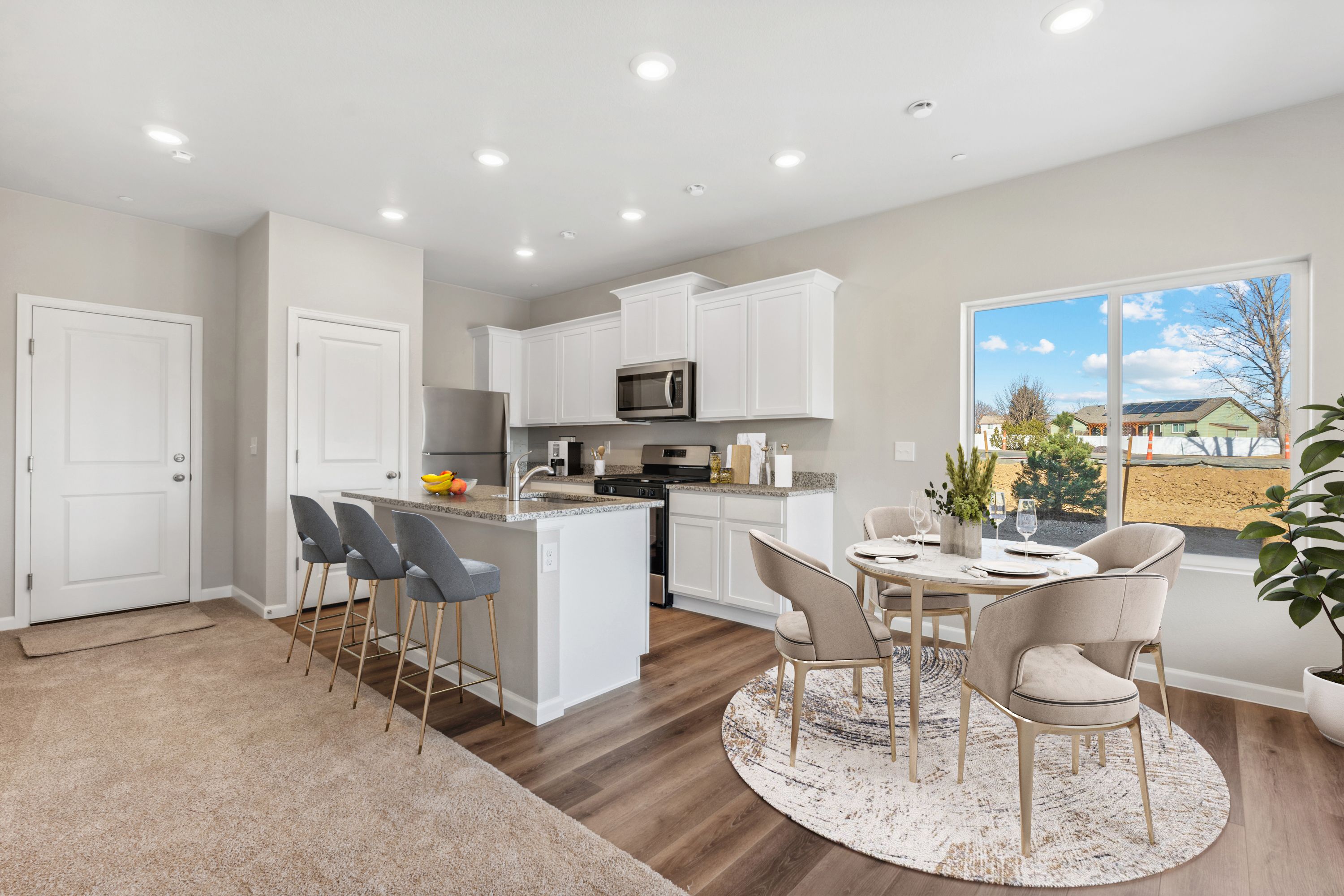 The kitchen has stainless steel appliances and plank flooring.
