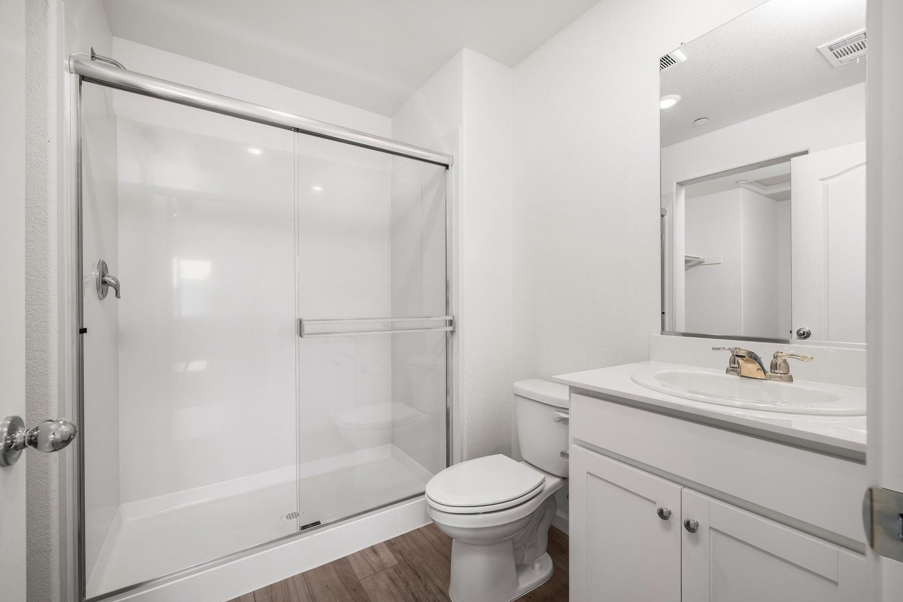 The master bathroom has a large vanity and step in shower.