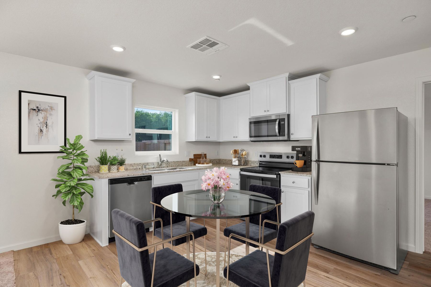 The kitchen has stainless steel appliances and plank flooring.