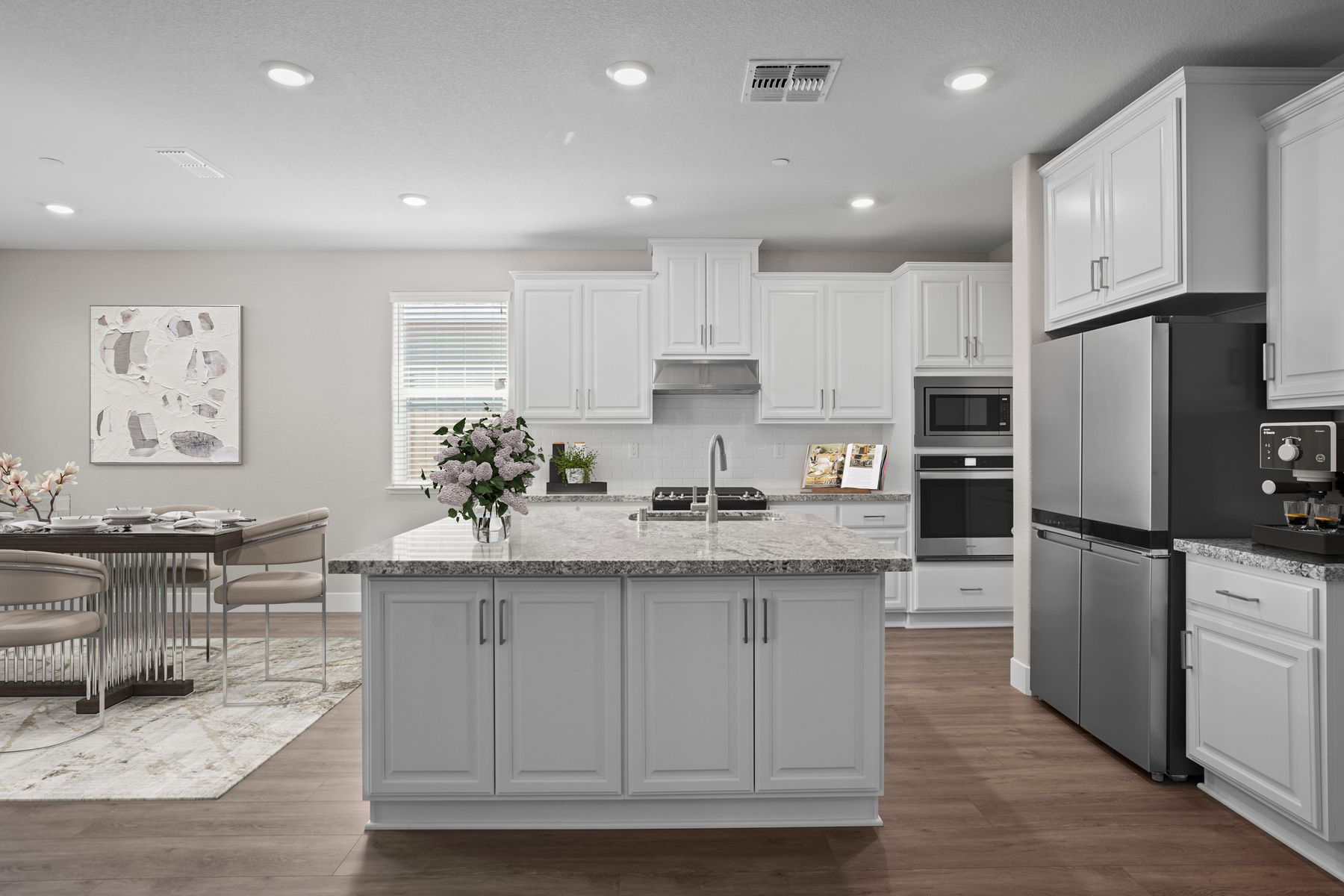 The kitchen has stainless steel appliances and plank flooring.