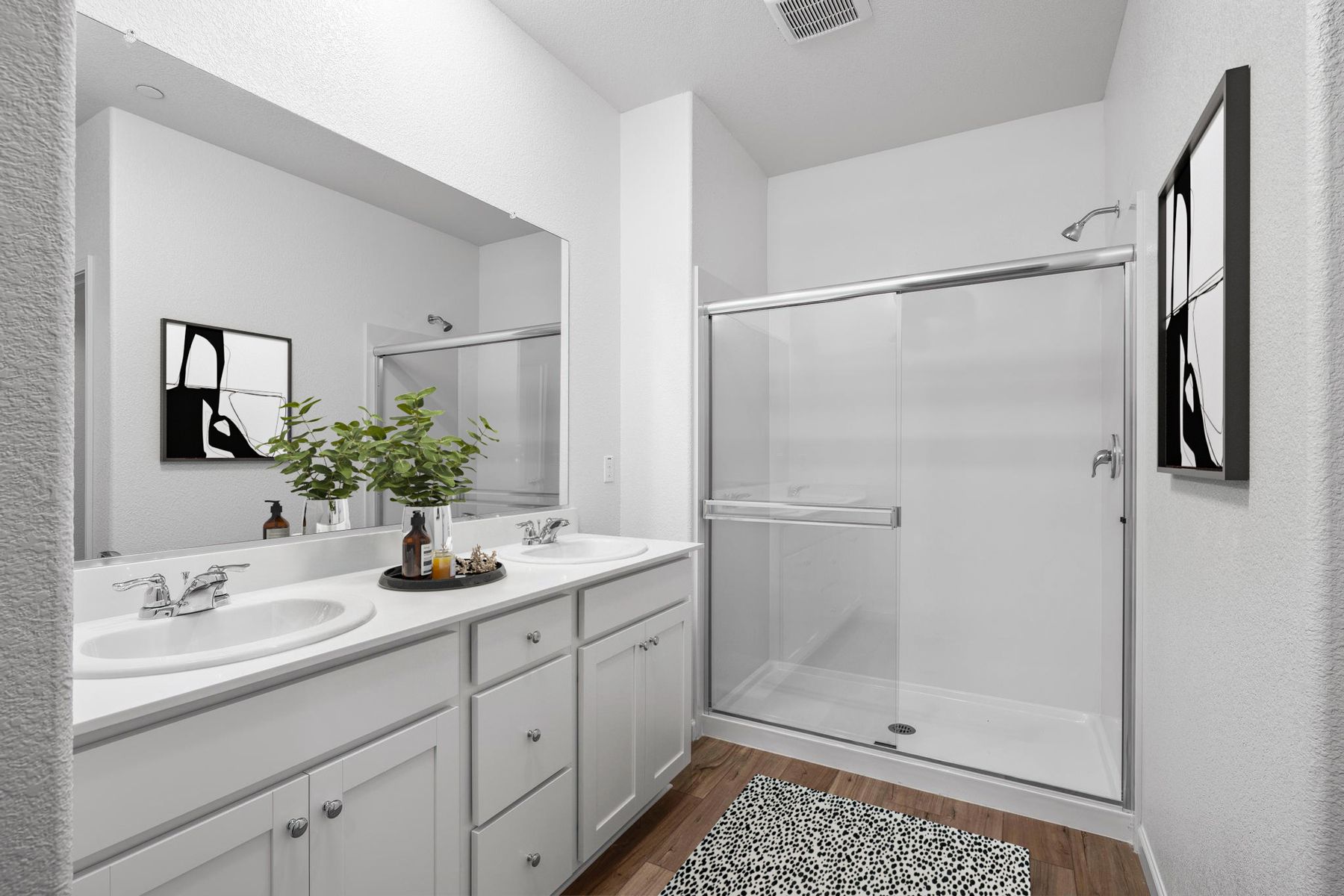 The master bathroom has a dual sink vanity and a step in shower.