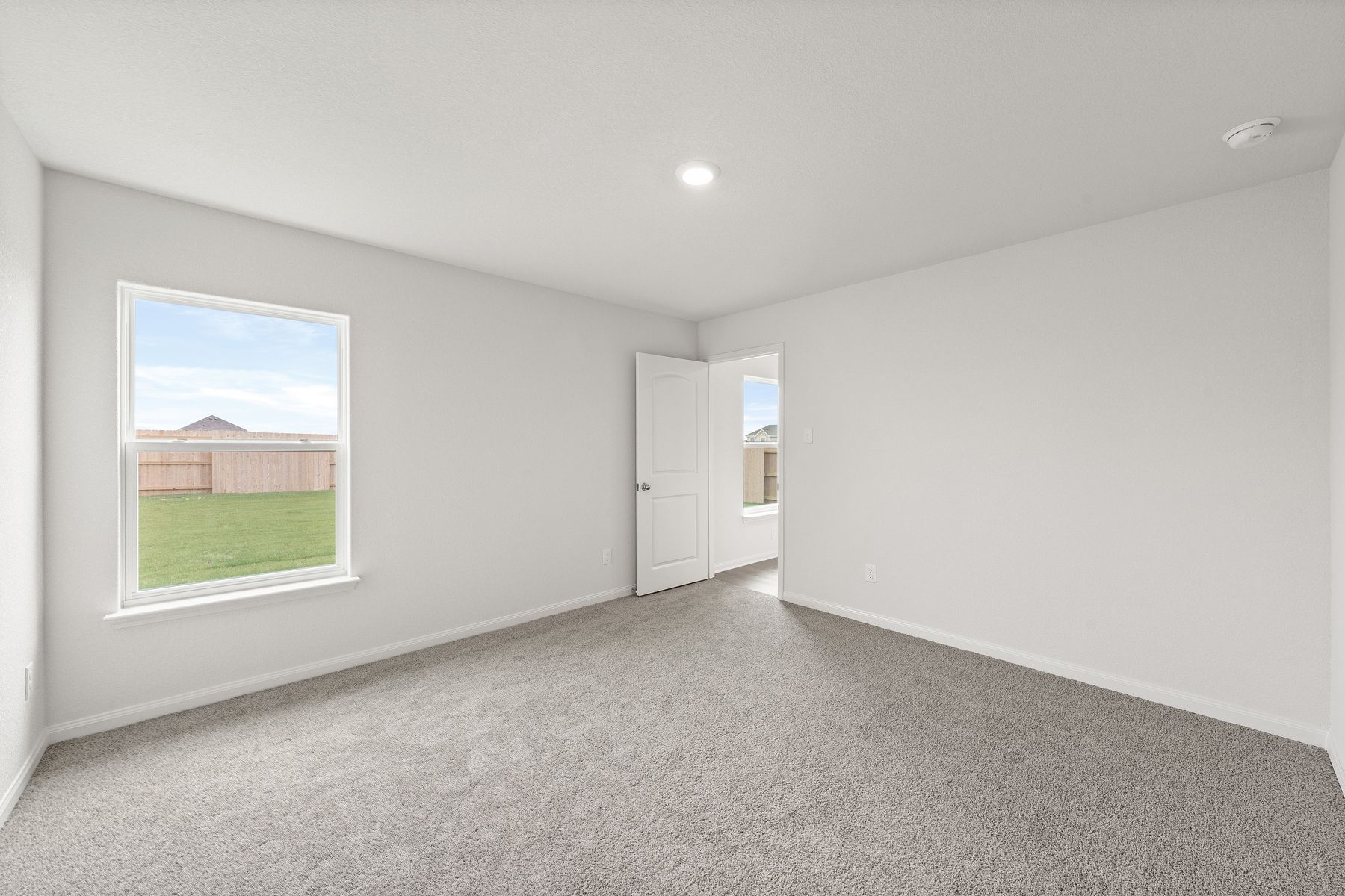 The master bedroom is spacious with a large window.